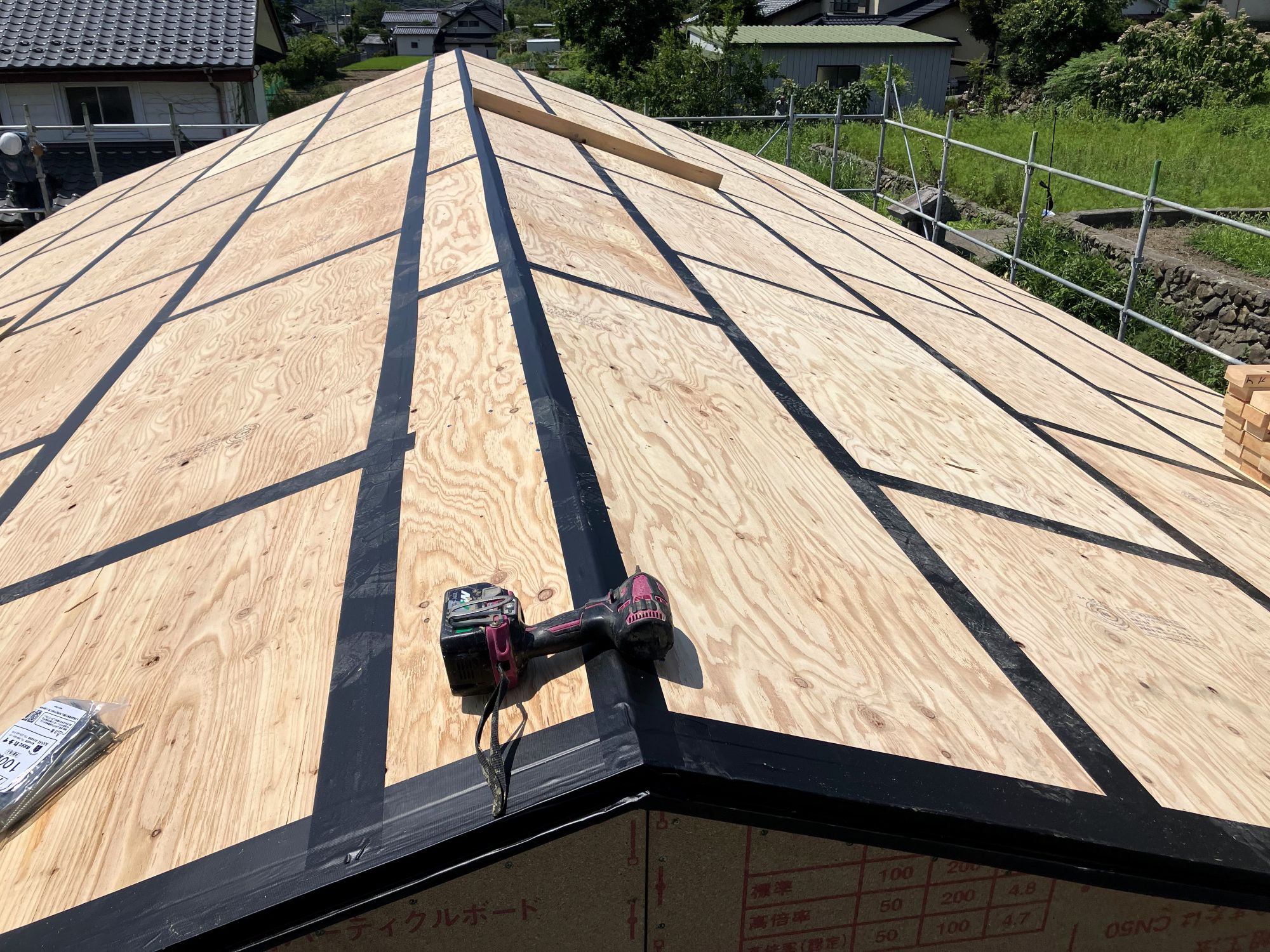屋根下地合板の継ぎ目を気密テープで処理する施工状況