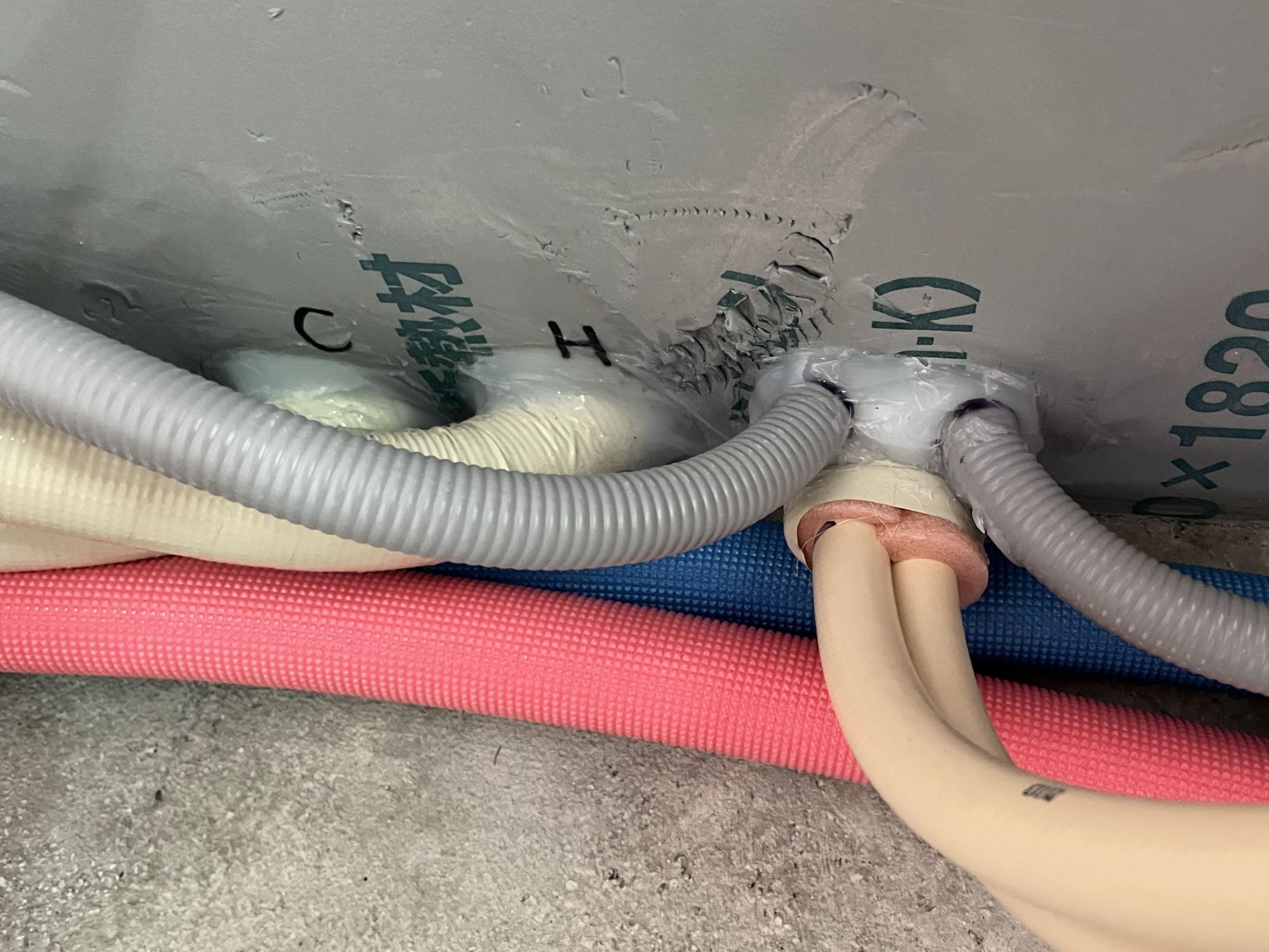 床下から立ち上がる給排水配管貫通部の気密処理施工状況