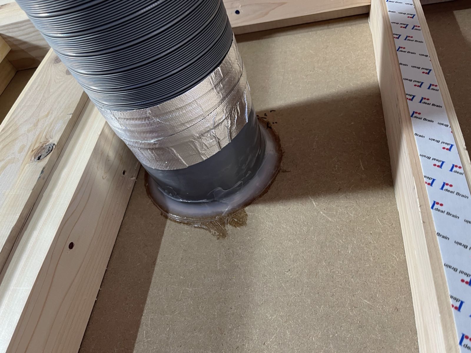 床や壁を貫通するダクトまわりを気密処理している施工中の様子