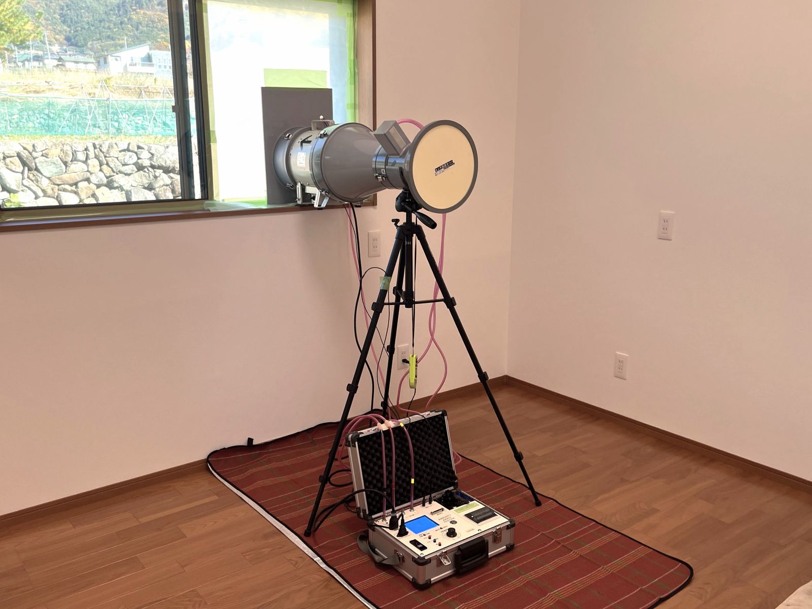 住宅完成前に行う気密測定の様子。送風機と測定機器を使い、実際の住まいの気密性能を現場で確認している