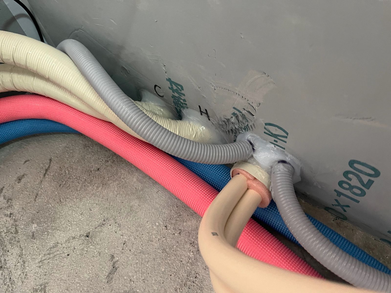 断熱層を貫通する配管部分を丁寧に気密処理している施工中の様子