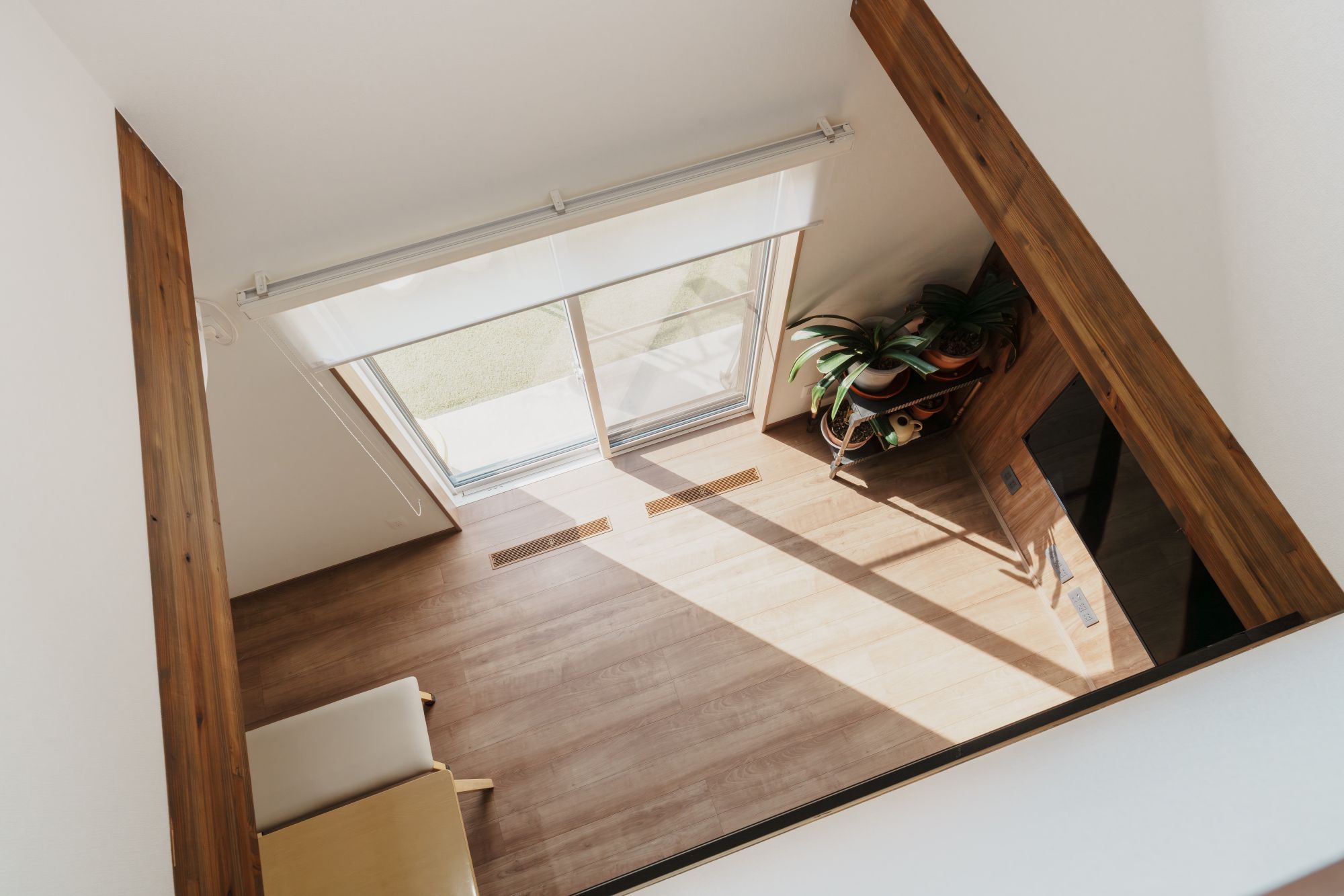 天窓から差し込む光を吹き抜け上部から斜めに見下ろした内観