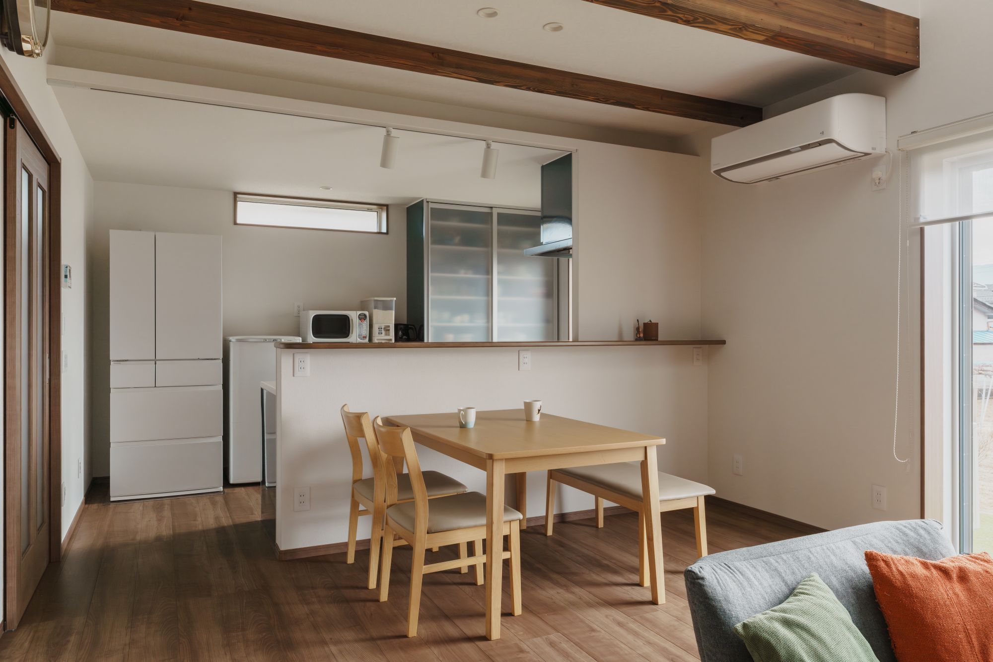 対面キッチンのカウンター越しにダイニングを見るLDKの内観