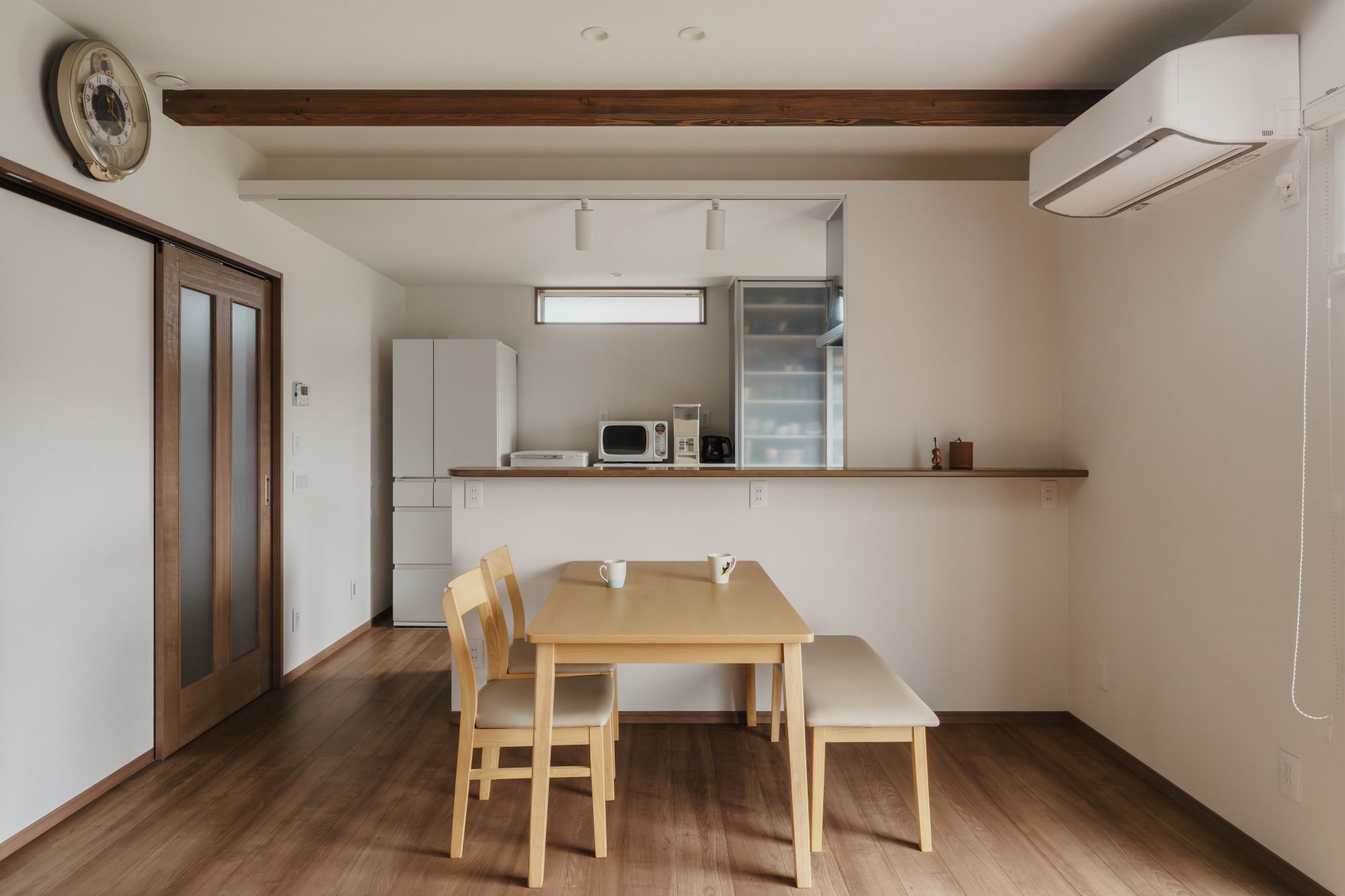 対面キッチン前に配置したダイニングを正面から見たLDKの内観