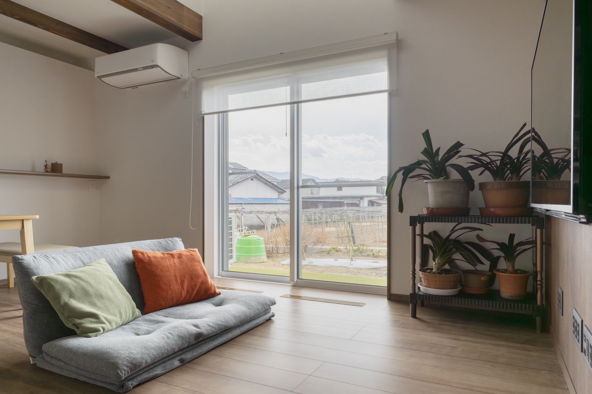 床座ソファと掃き出し窓で庭につながるリビングの内観