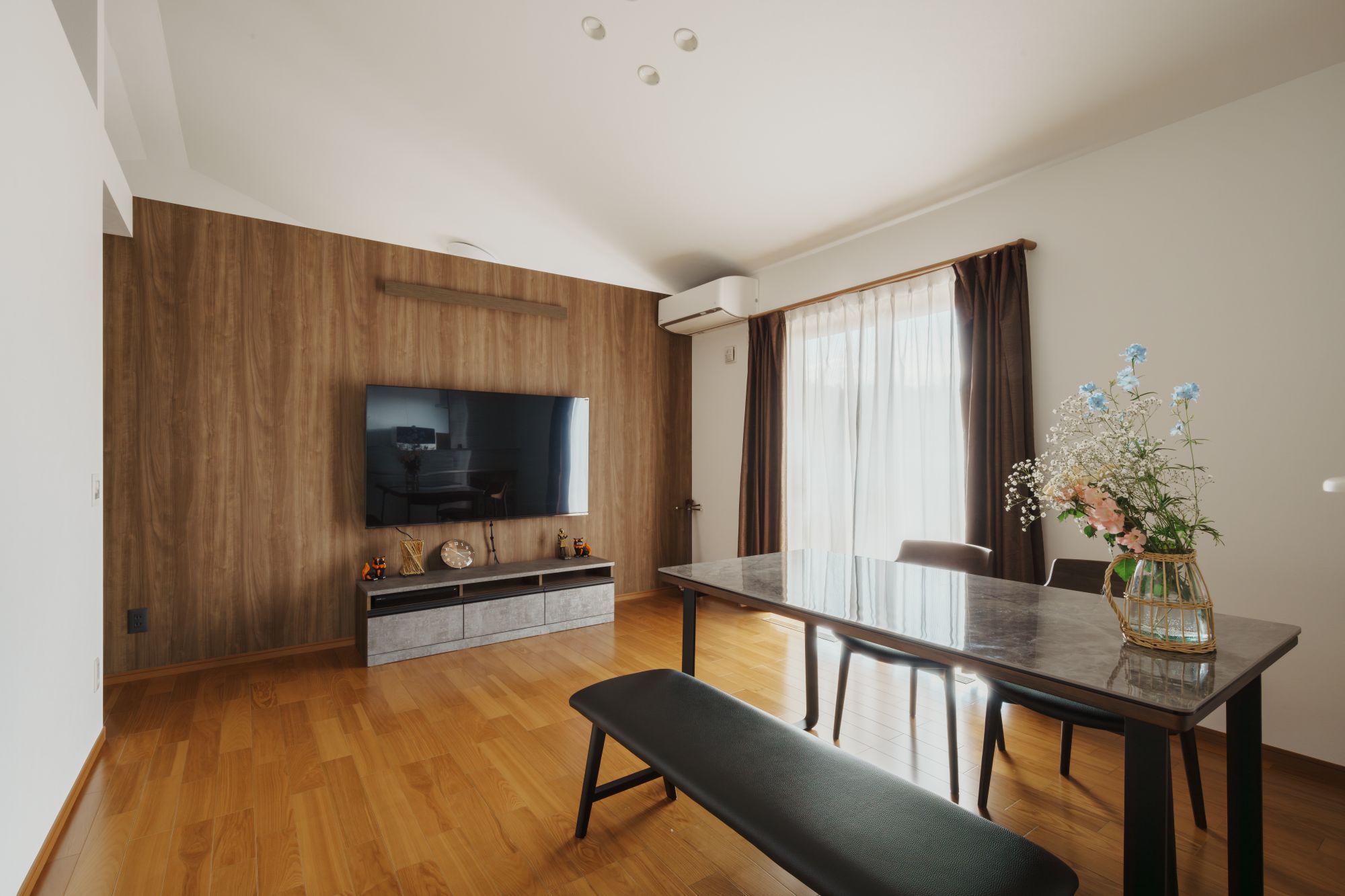ダイニングとテレビ背面の木目壁が見えるLDK