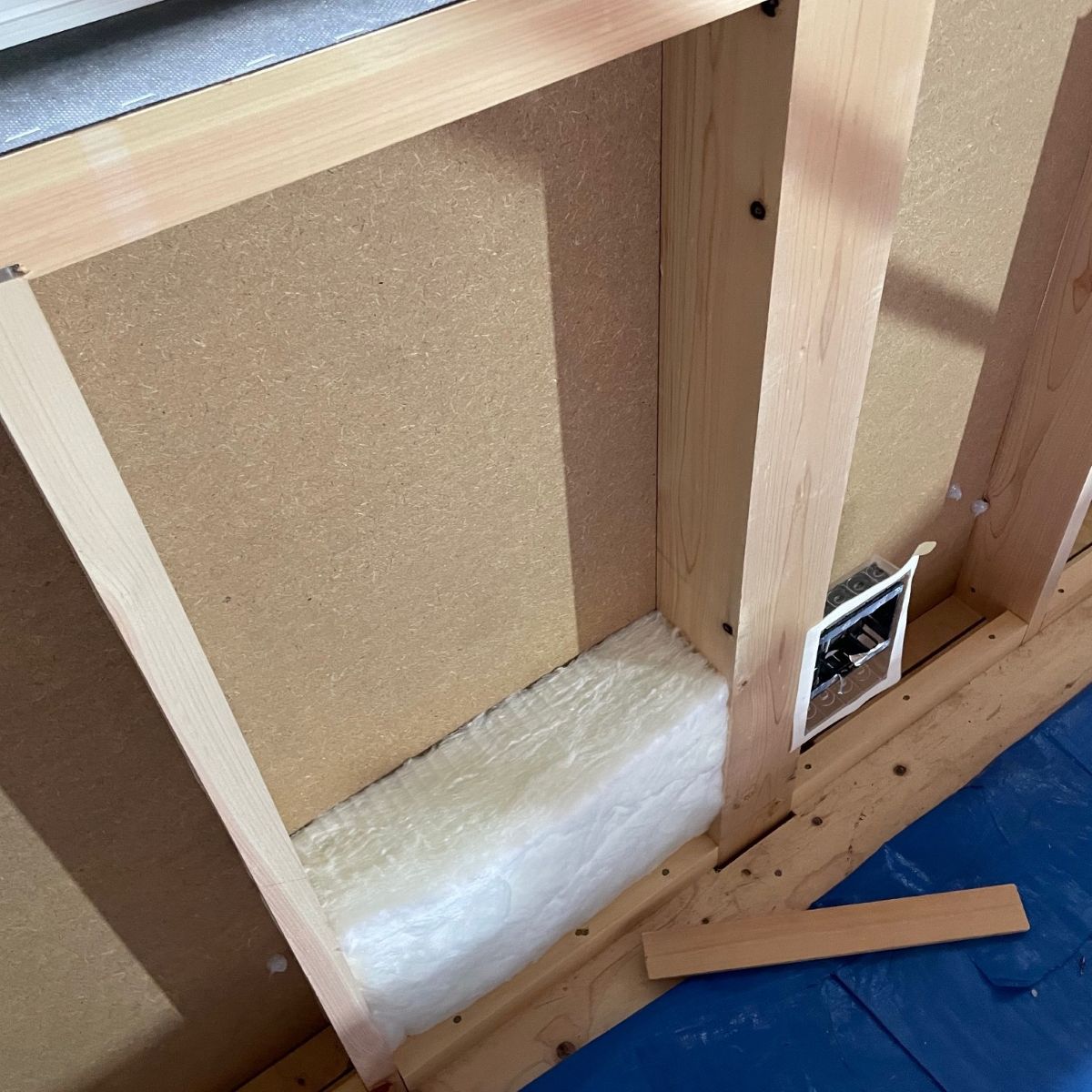 柱間の奥まで隙間なく充填されたグラスウール断熱施工の様子