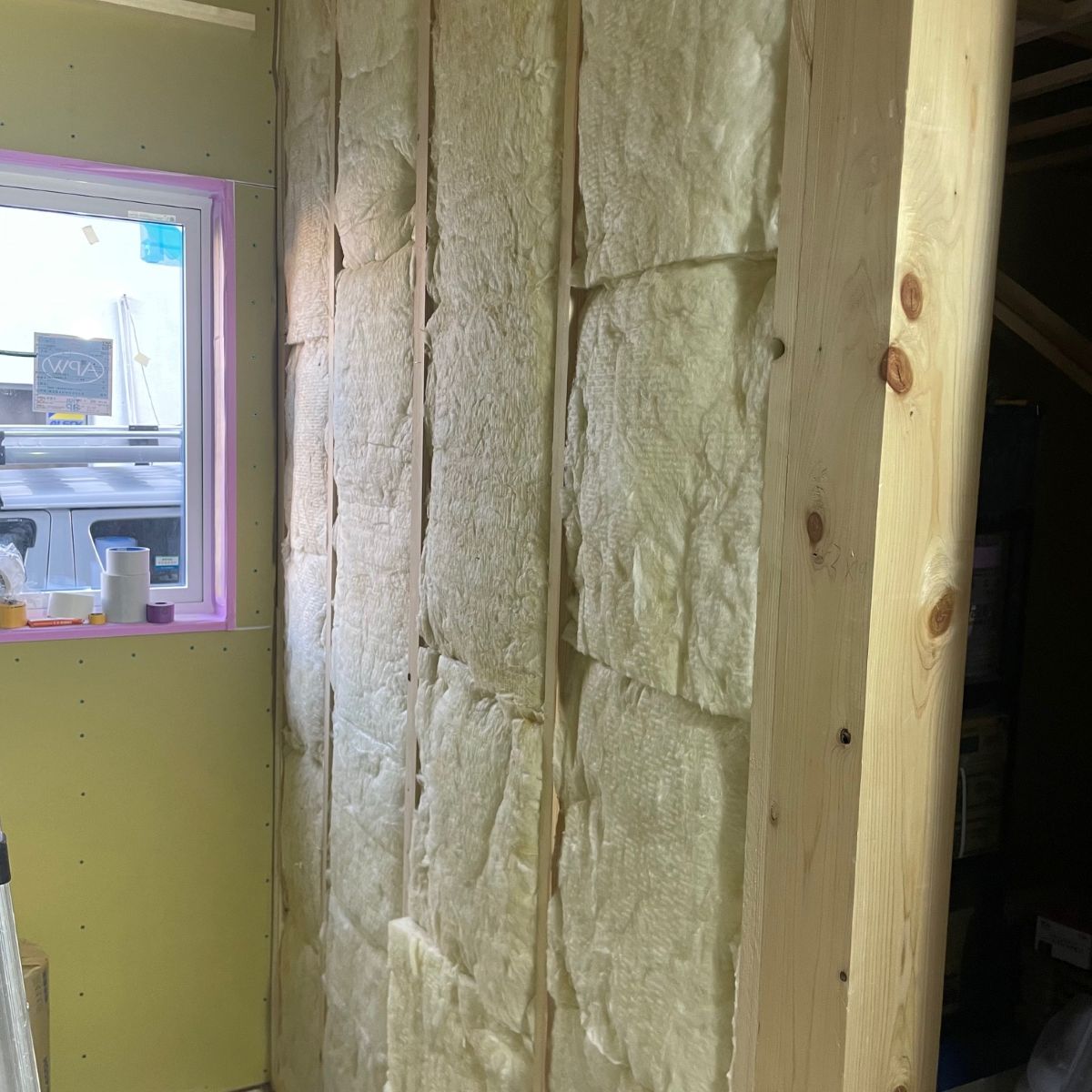 柱間に高性能グラスウールを隙間なく充填している遮音施工の様子