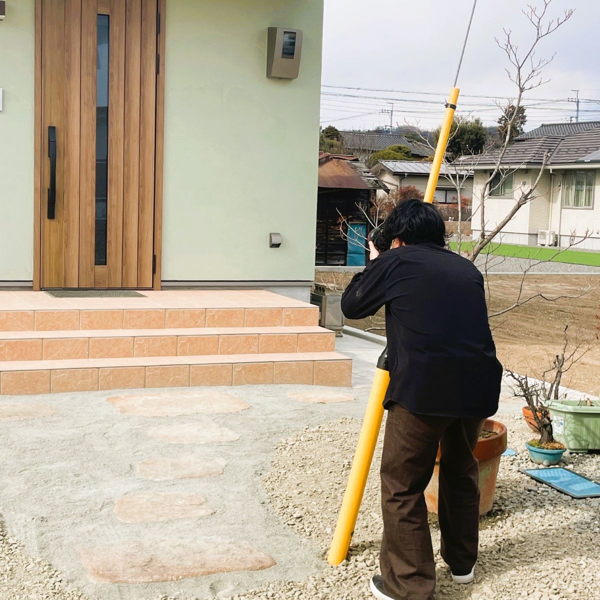 完成した住宅の玄関アプローチを撮影している様子