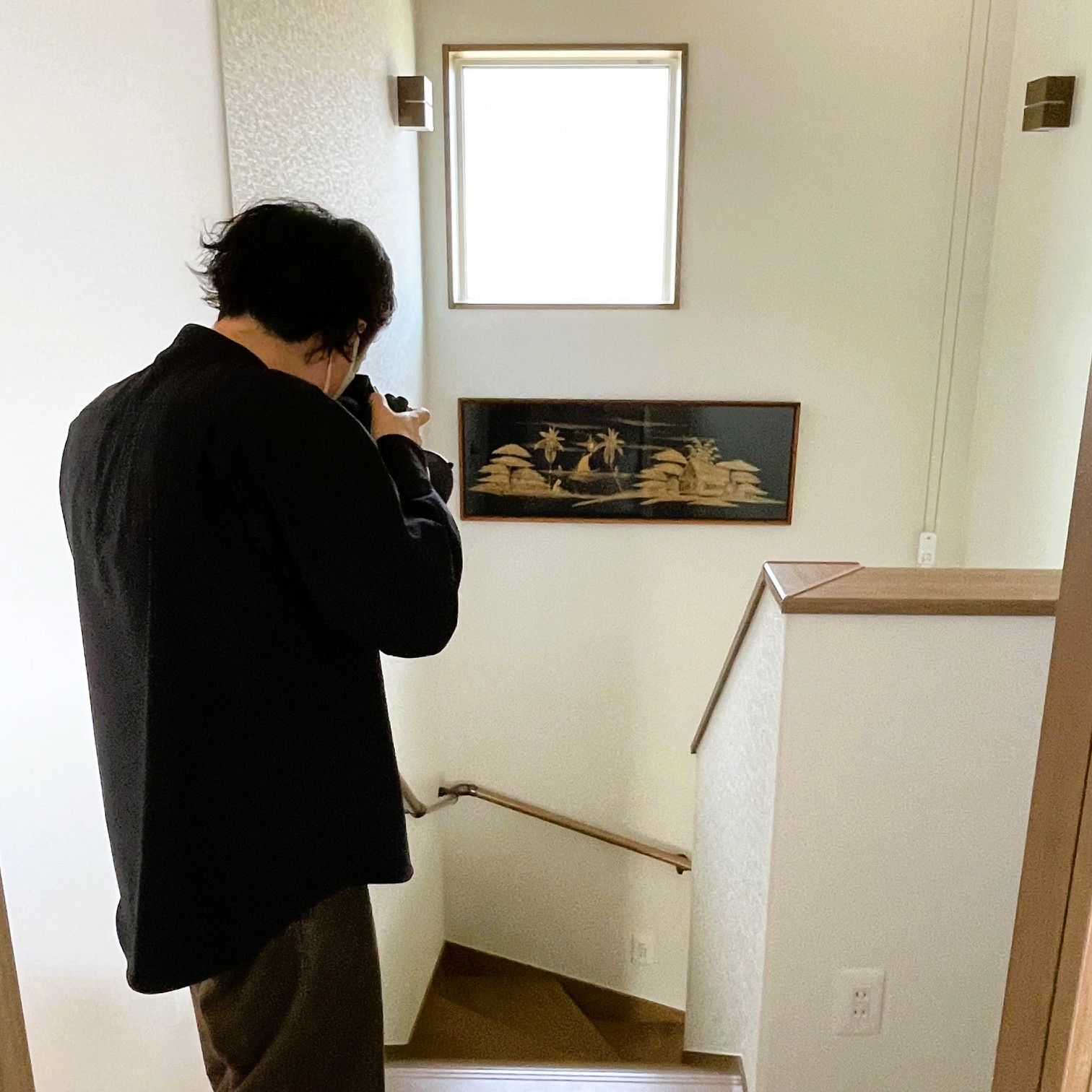 完成住宅の階段ホールを撮影している様子