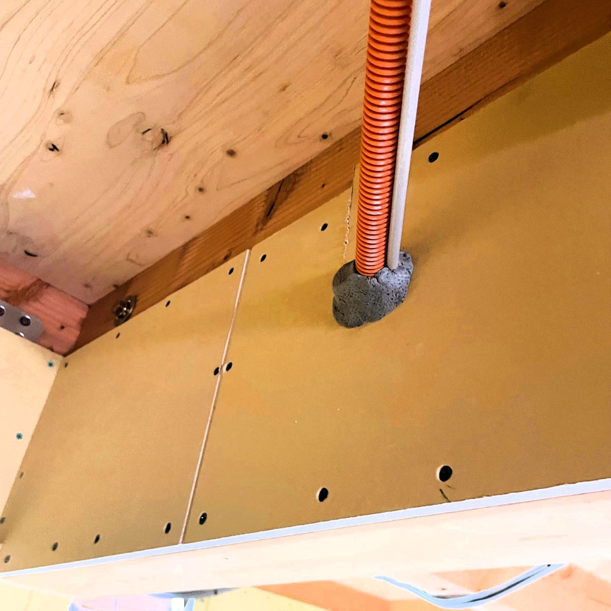 防火地域における配線貫通部を不燃パテで処理している施工状況