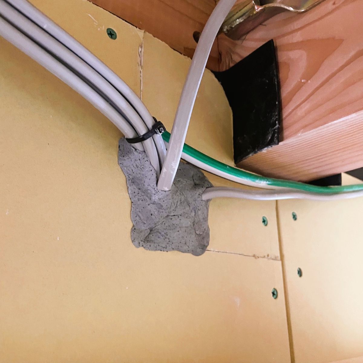 防火地域における配線貫通部を不燃パテで処理した施工状況（構造部との取り合い）