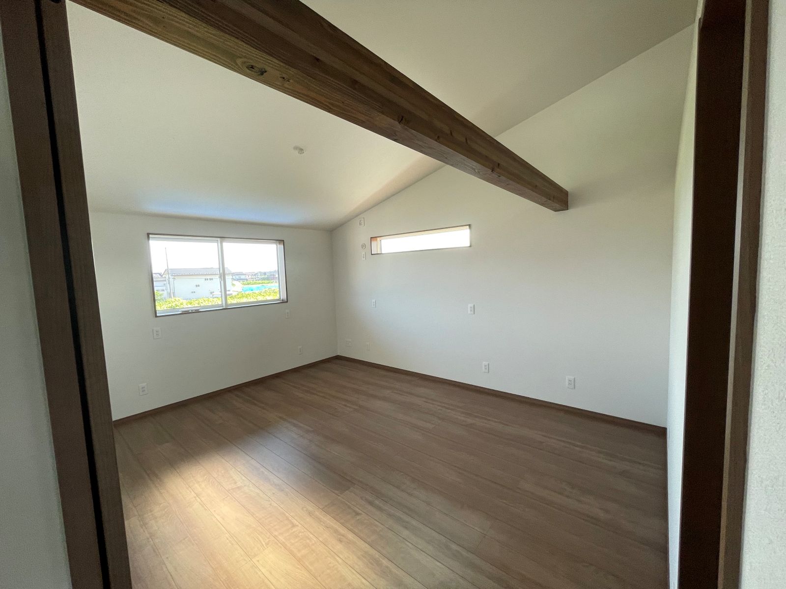 2階居室の化粧梁と勾配天井のあるシンプルな空間