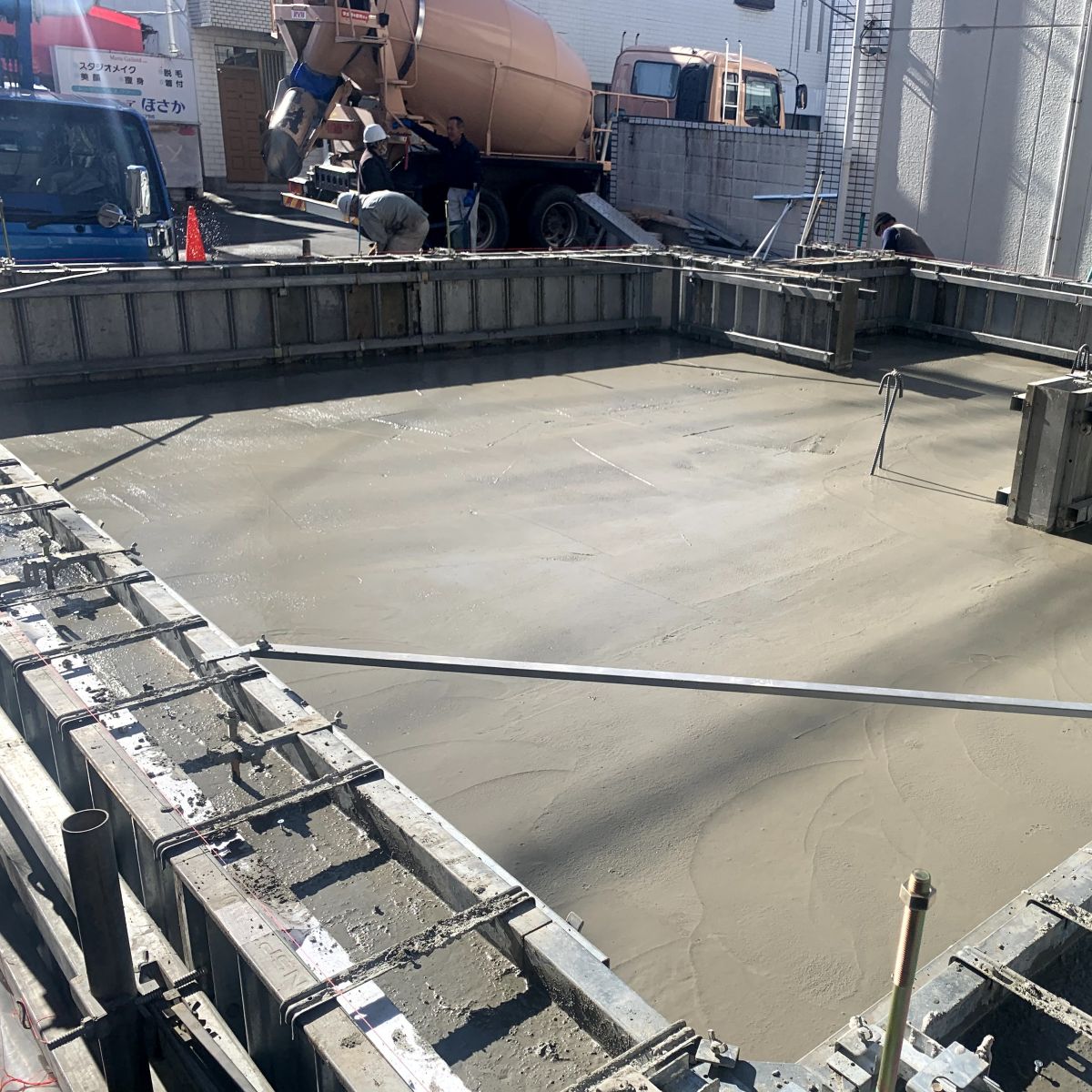 コンクリート打設直後の基礎スラブと一体打ち施工の様子