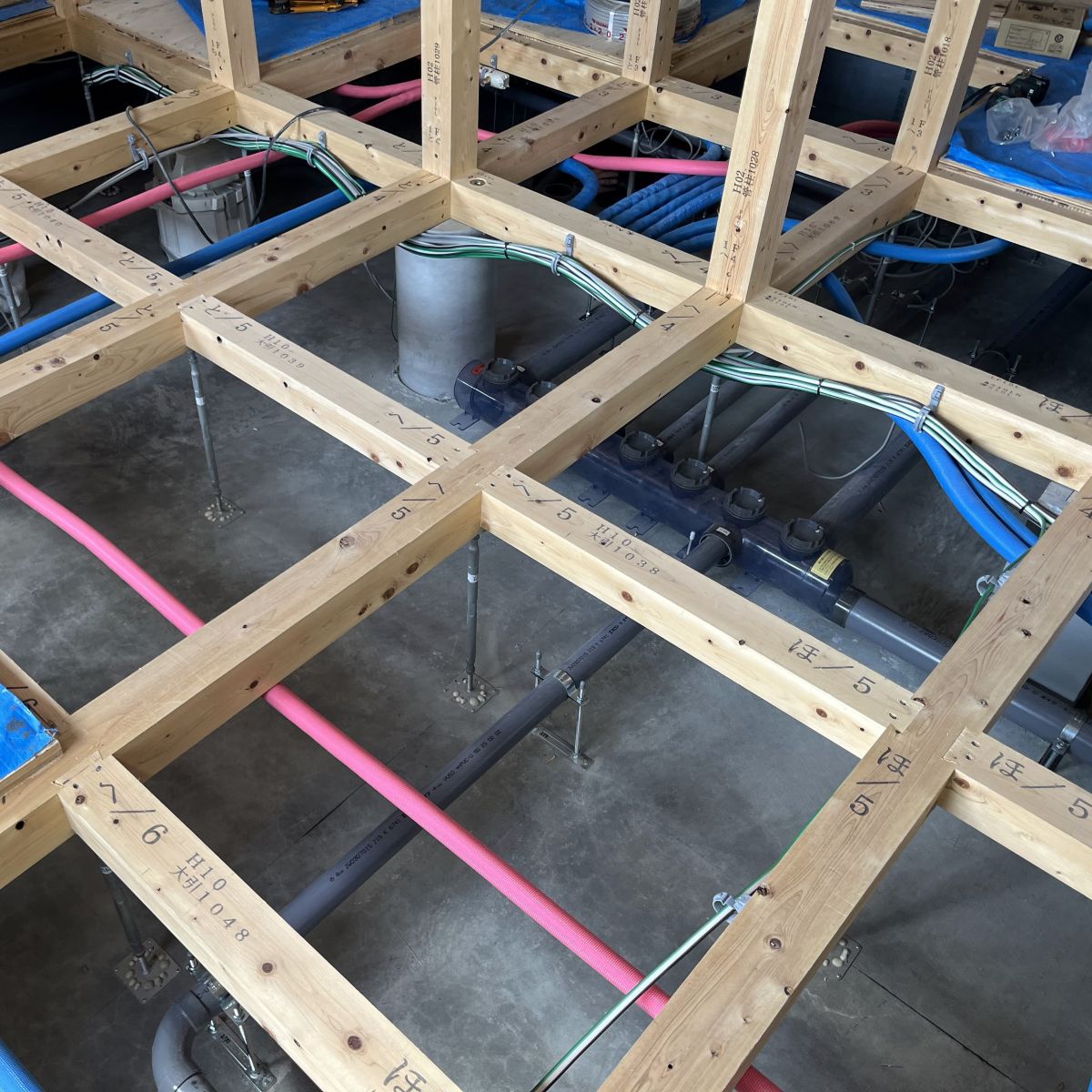 床下の配線と配管を整理し、構造材と干渉しないよう丁寧に施工した様子