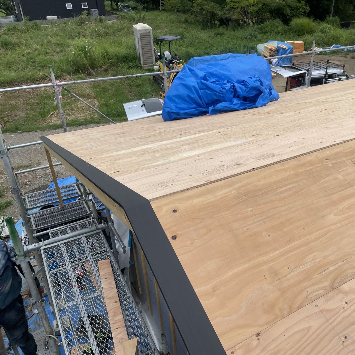 屋根の野地板の木口に防水テープを施工し耐久性を高めている様子