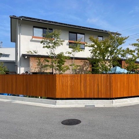 木製フェンスと植栽で囲われたナチュラルな外構