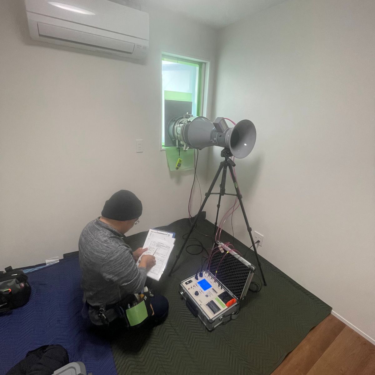 住宅の気密測定を行っている様子（ブロワードア試験）