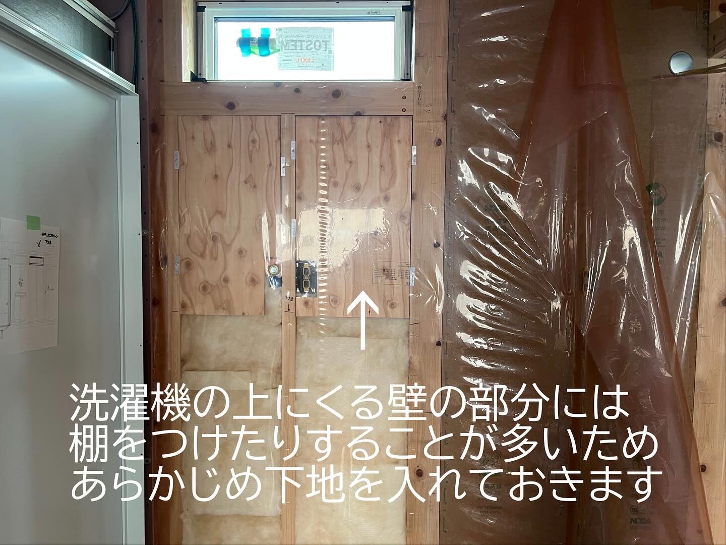 洗濯機上の壁に棚設置用の下地合板を施工している様子