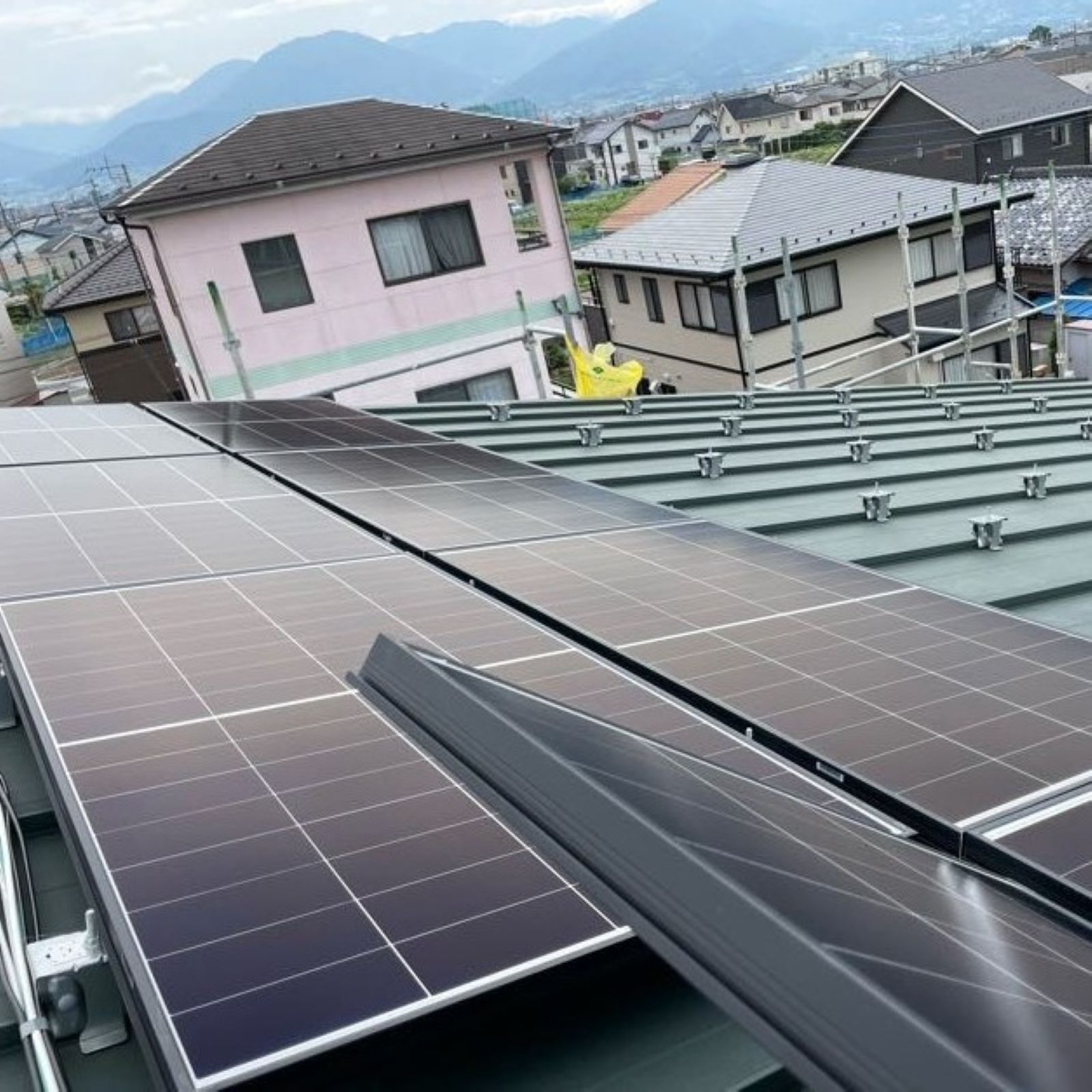 ガルバリウム鋼板屋根に太陽光パネルを設置している施工中の様子