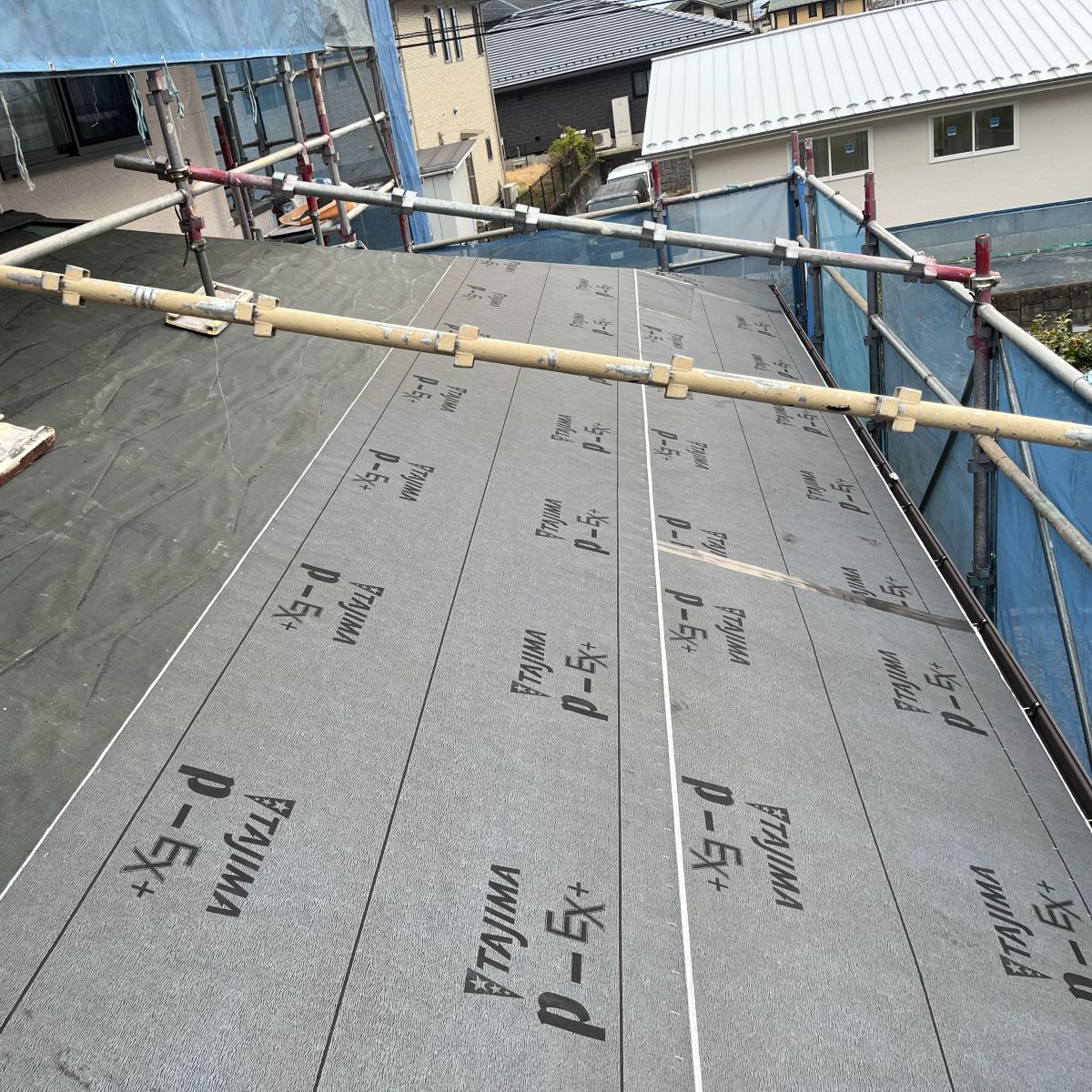 既存のコロニアル屋根材をすべて撤去した後の状態。下地のルーフィング（防水層）が露出しており、経年による劣化や損傷の有無を確認する重要な工程。この状態を確認せずにカバー工法を行うと、見えない部分の劣化を見逃すリスクがあるため、長期的な耐久性を重視する場合は葺き替え工事が有効となる。