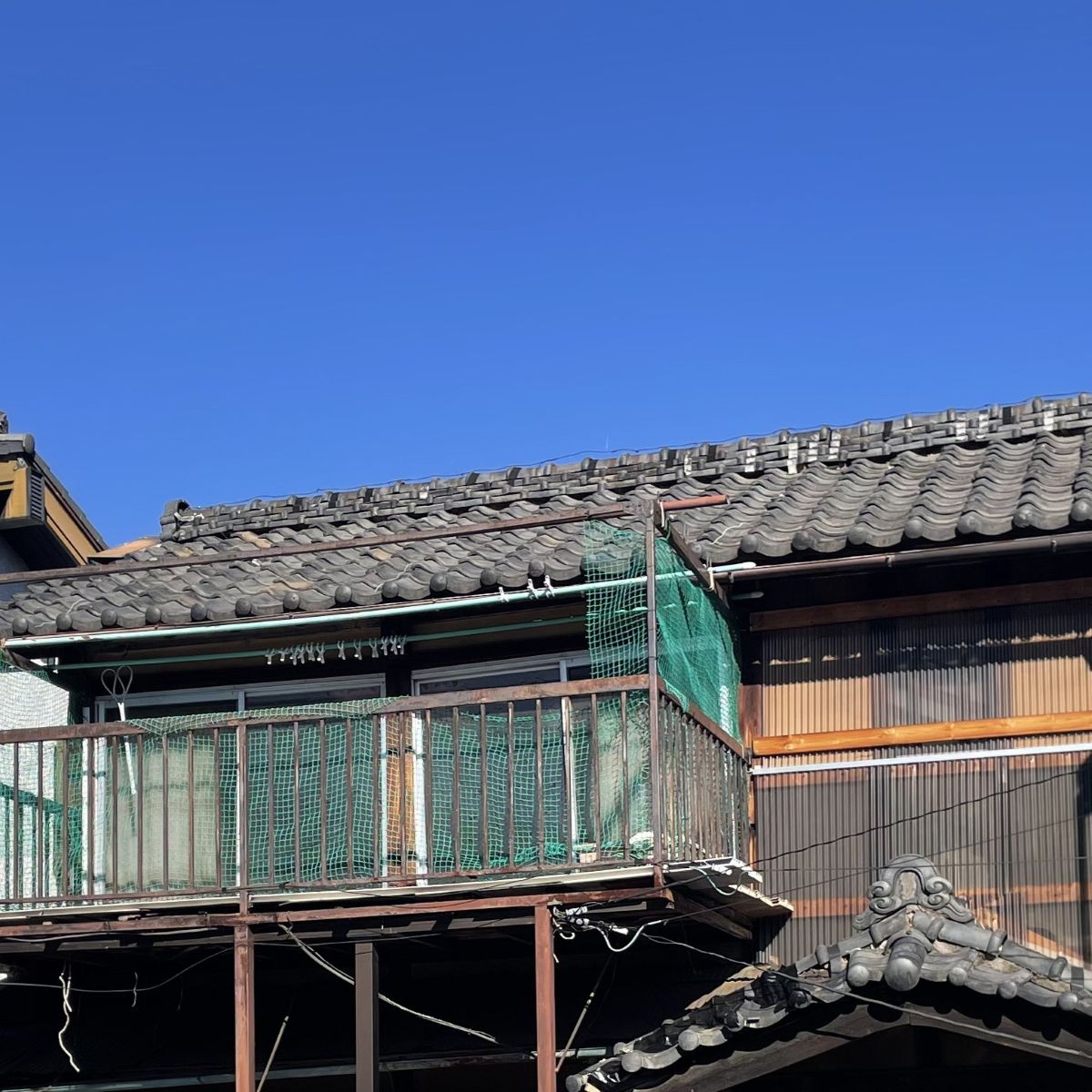 屋根や外装に経年劣化が見られる改修前の住宅外観