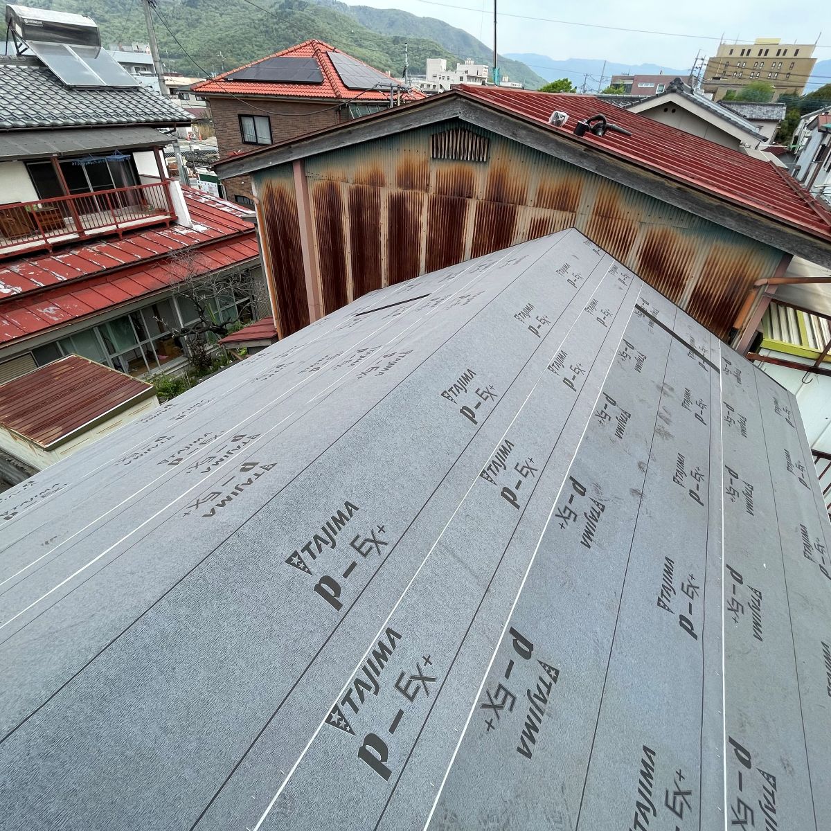 新しい野地板の上にルーフィングを敷いて防水処理をしている屋根改修の様子