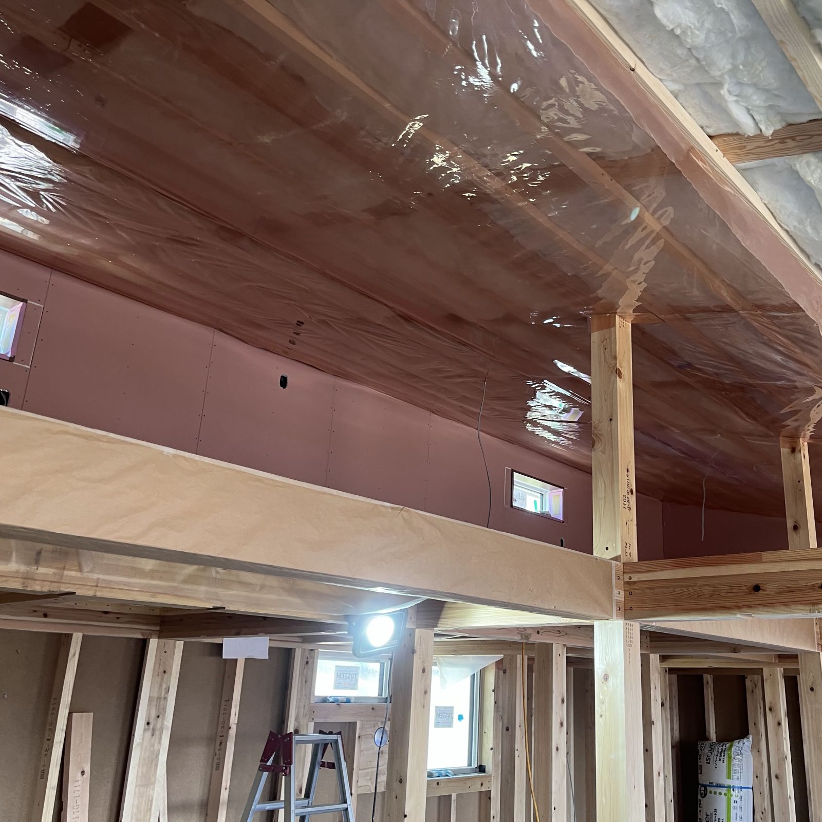 屋根面に気密シートと断熱材を施工している様子