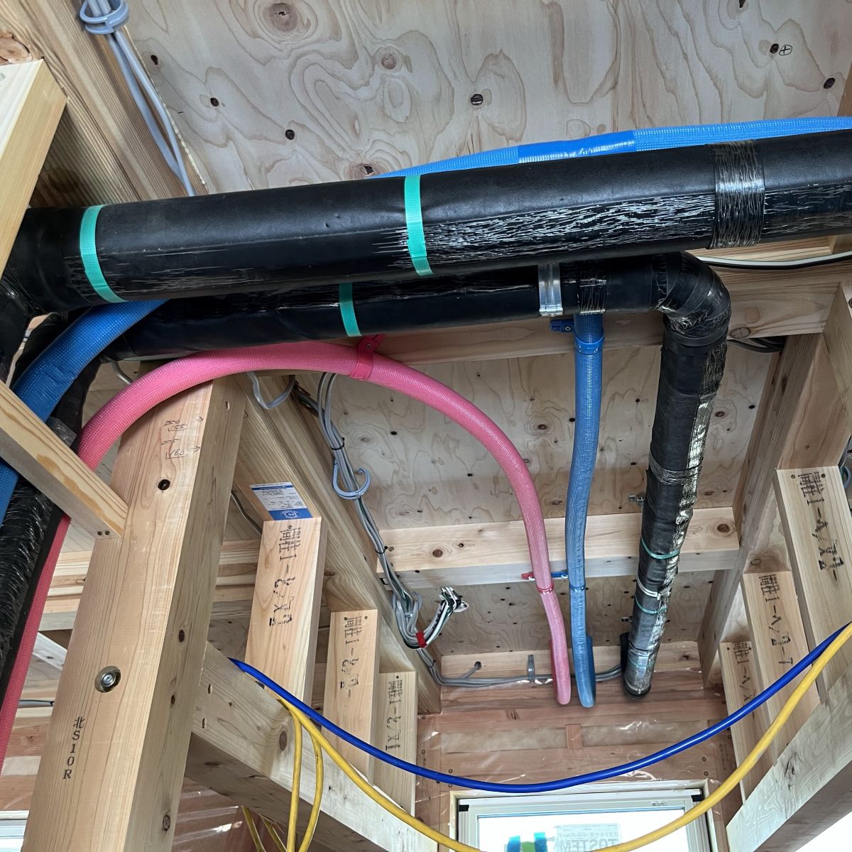 1階天井裏を通る2階の給排水配管の施工状況