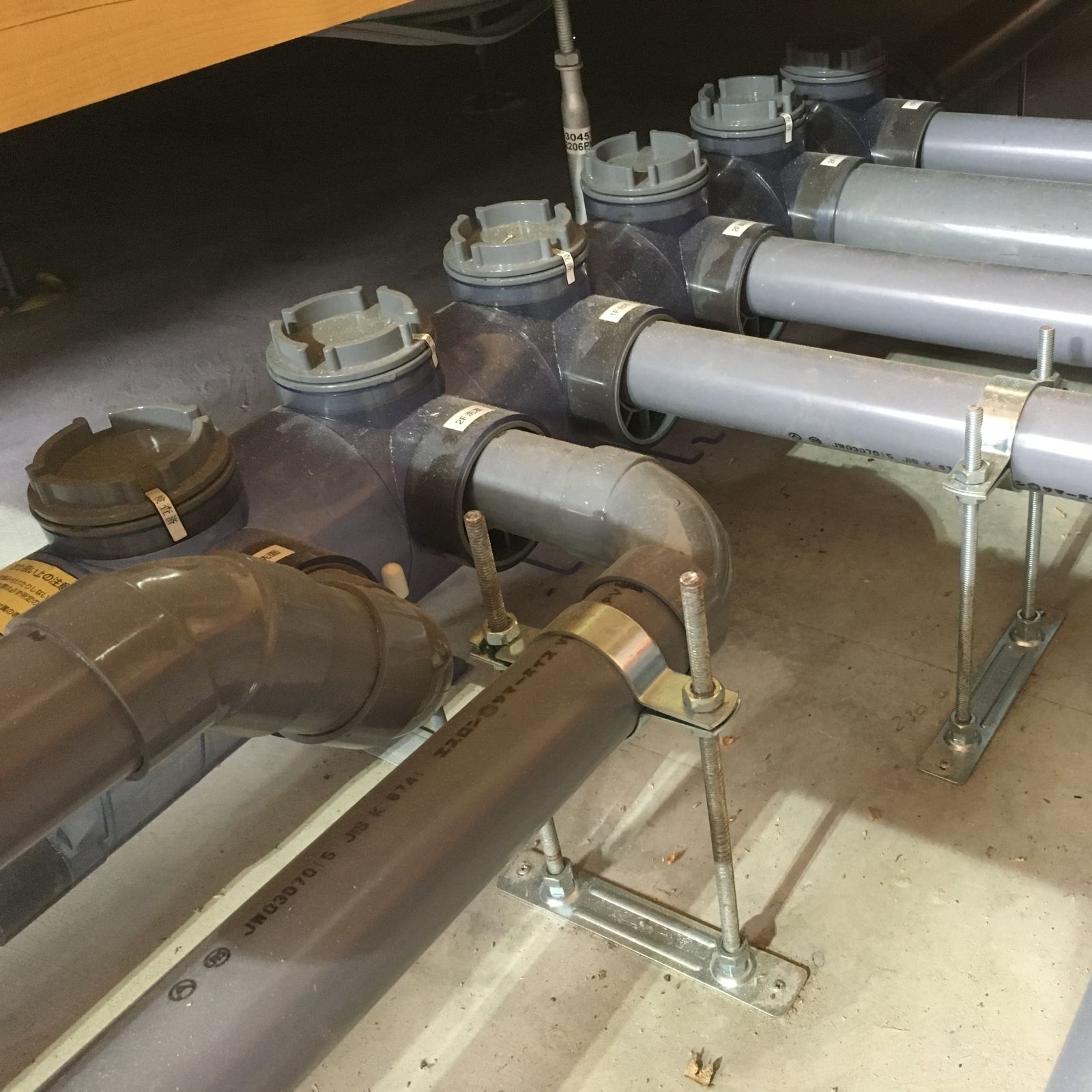 床下に設置された排水ヘッダーと各排水配管