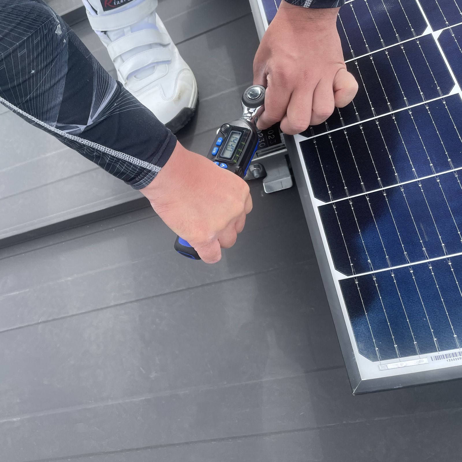 デジタルトルクレンチで太陽光パネルの固定金具を適正トルクで締め付けている様子
