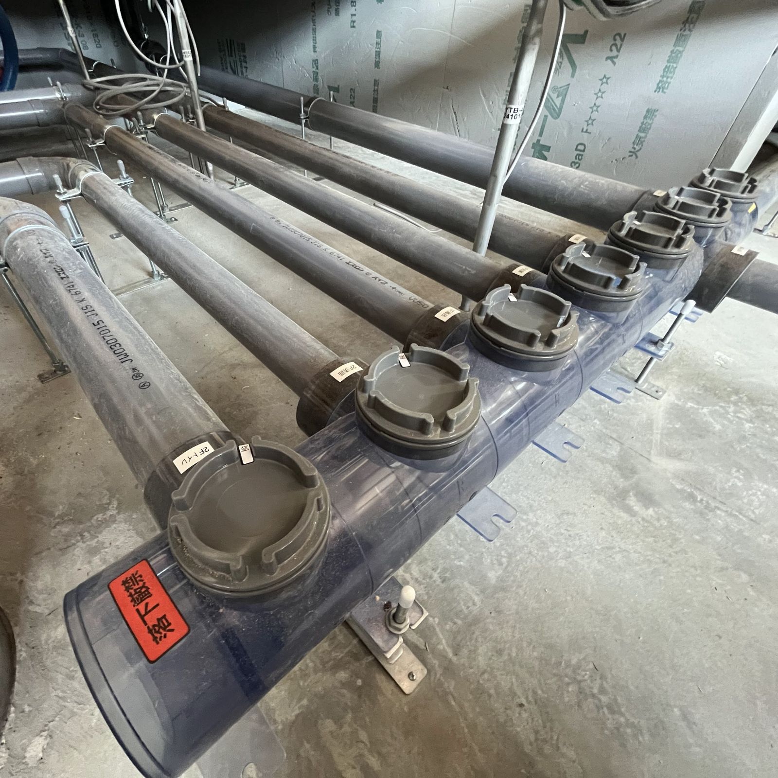 床下に設置された排水ヘッダーと分岐配管の様子