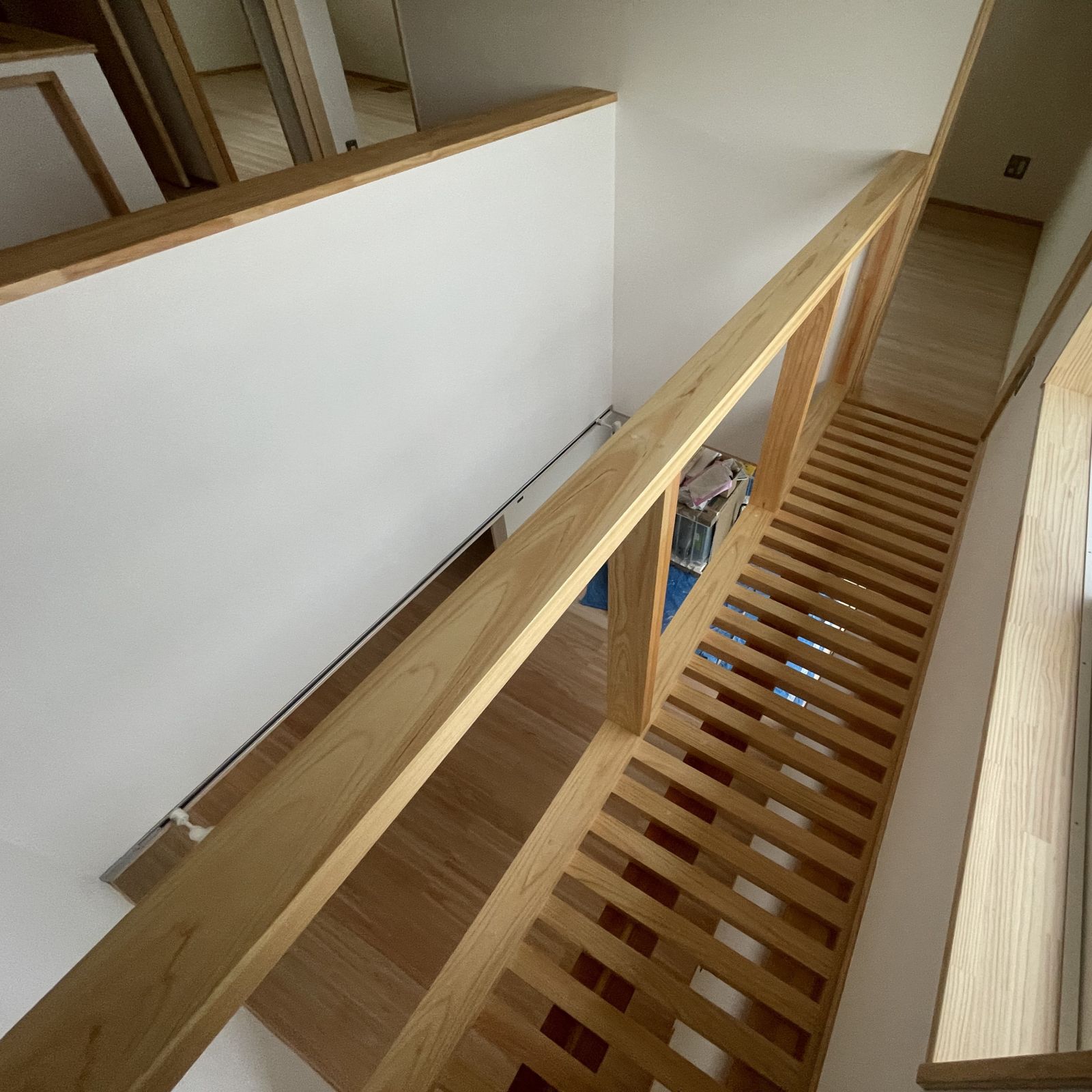 格子床の廊下とつながる吹き抜けで上下階の空気循環を促す設計