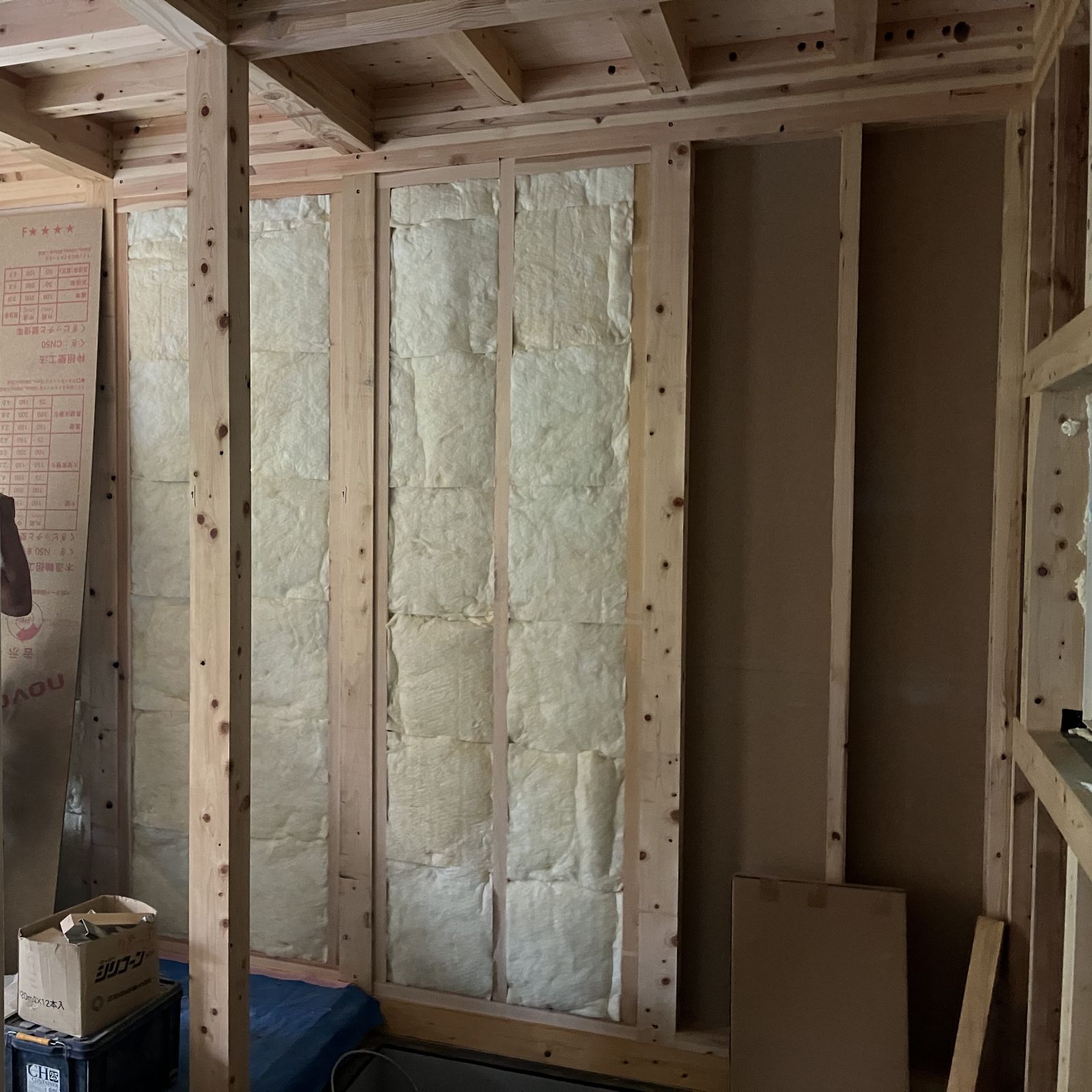 木造住宅の壁内に断熱材を隙間なく充填している施工状況