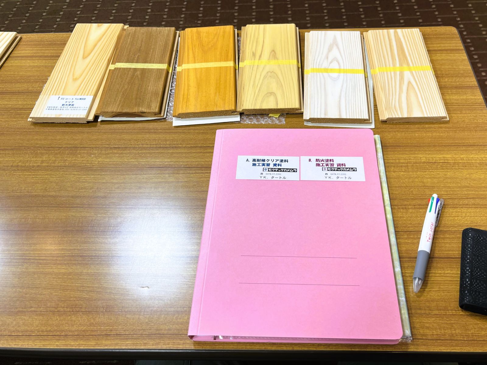 講習資料と塗装サンプルが並ぶ液体ガラス塗料講習会の様子