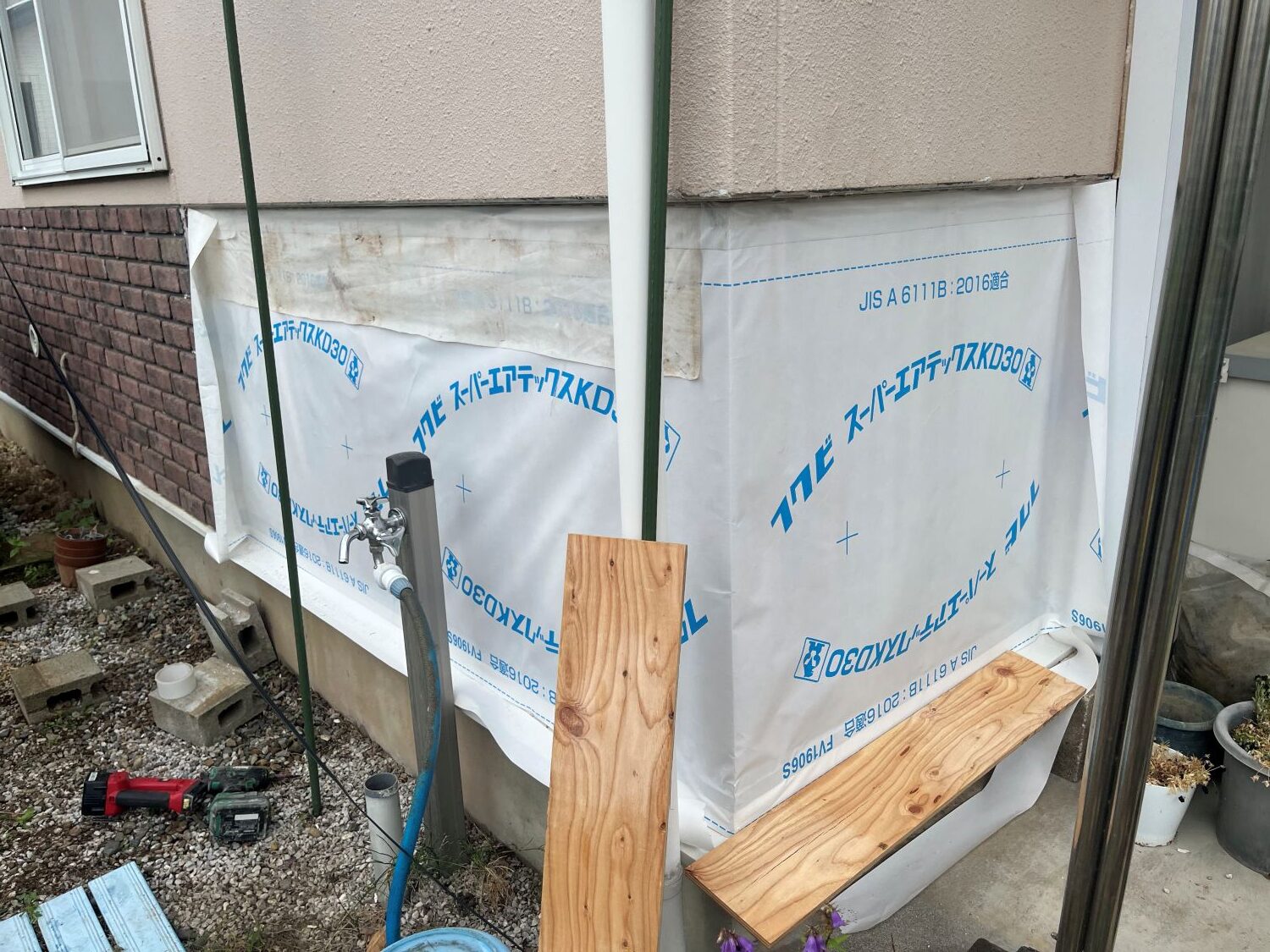 外壁補修後に透湿防水シートを施工している様子