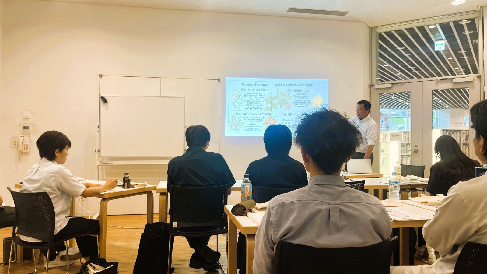 山梨県木造住宅協会の木部塗装勉強会で、オスモ&エーデル株式会社による自然塗料の説明を聞いている様子