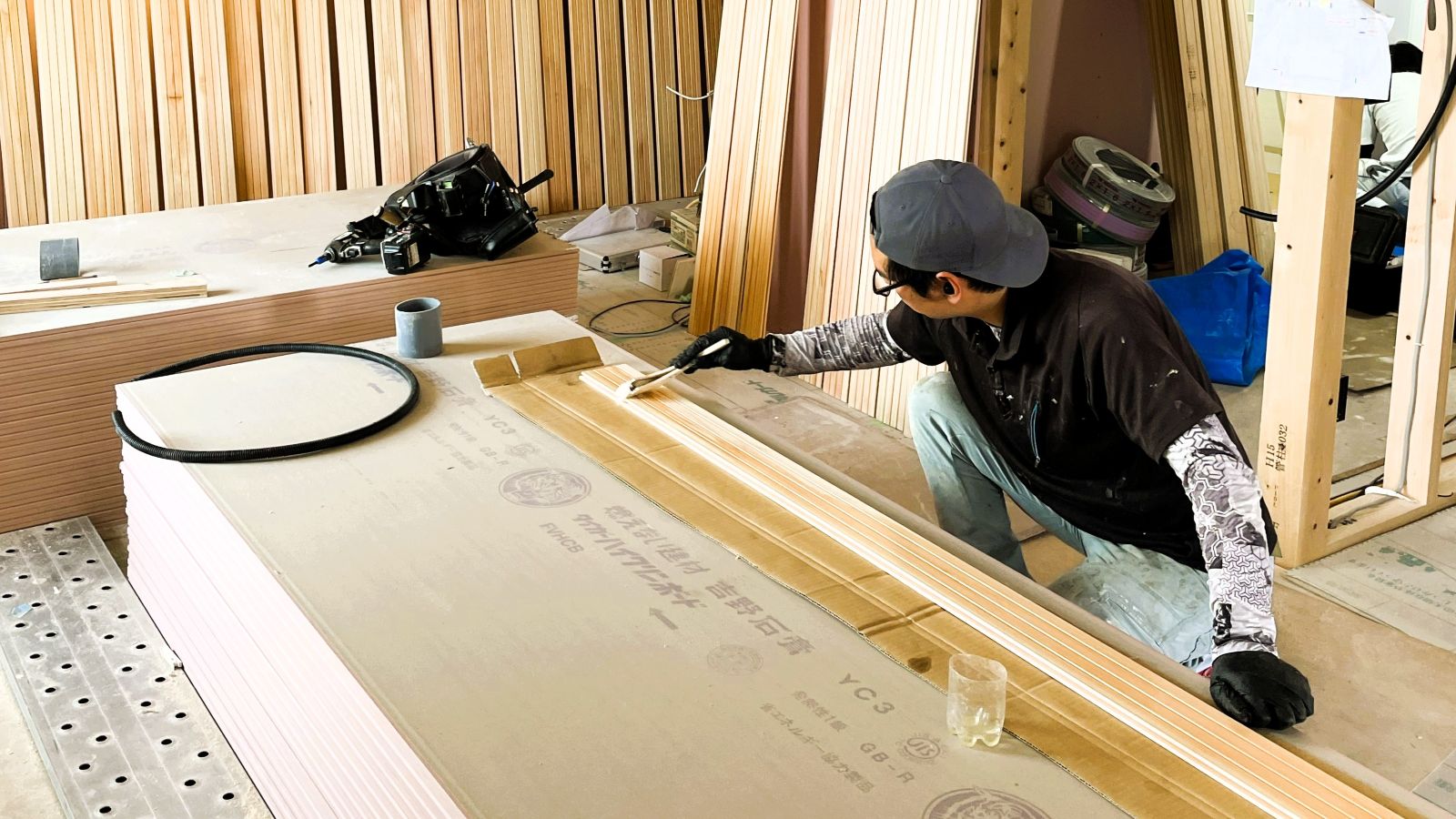 山本建築工業の現場で木部材に自然塗料を塗装している様子