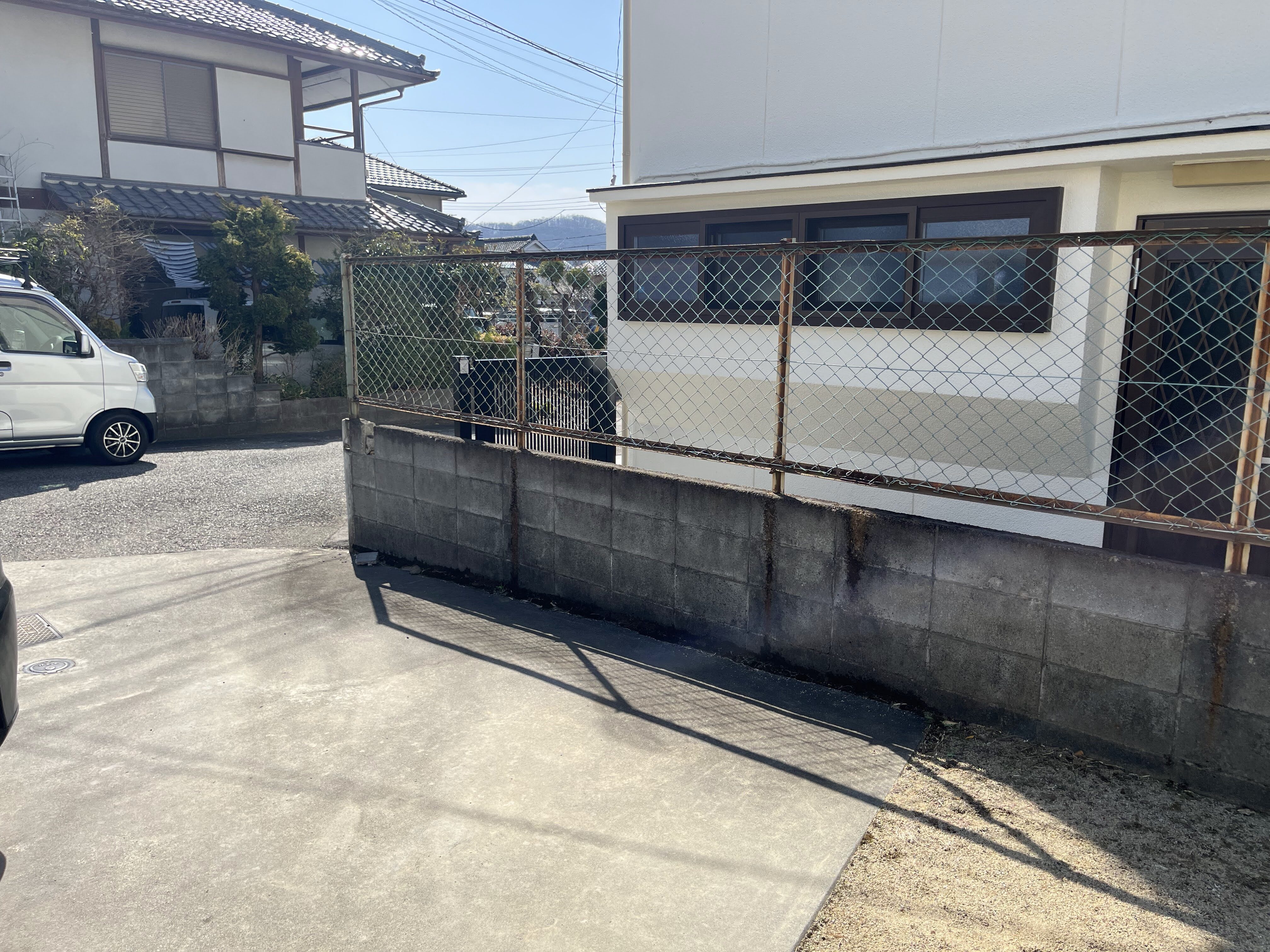 道路側から見た経年劣化したブロック塀とフェンスの施工前の様子