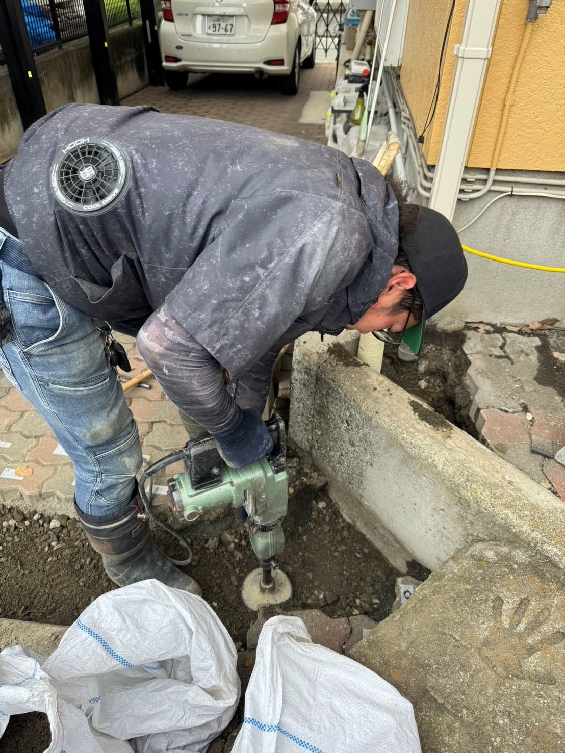 給水管やり直し工事後に砕石で埋め戻しを行い転圧している様子