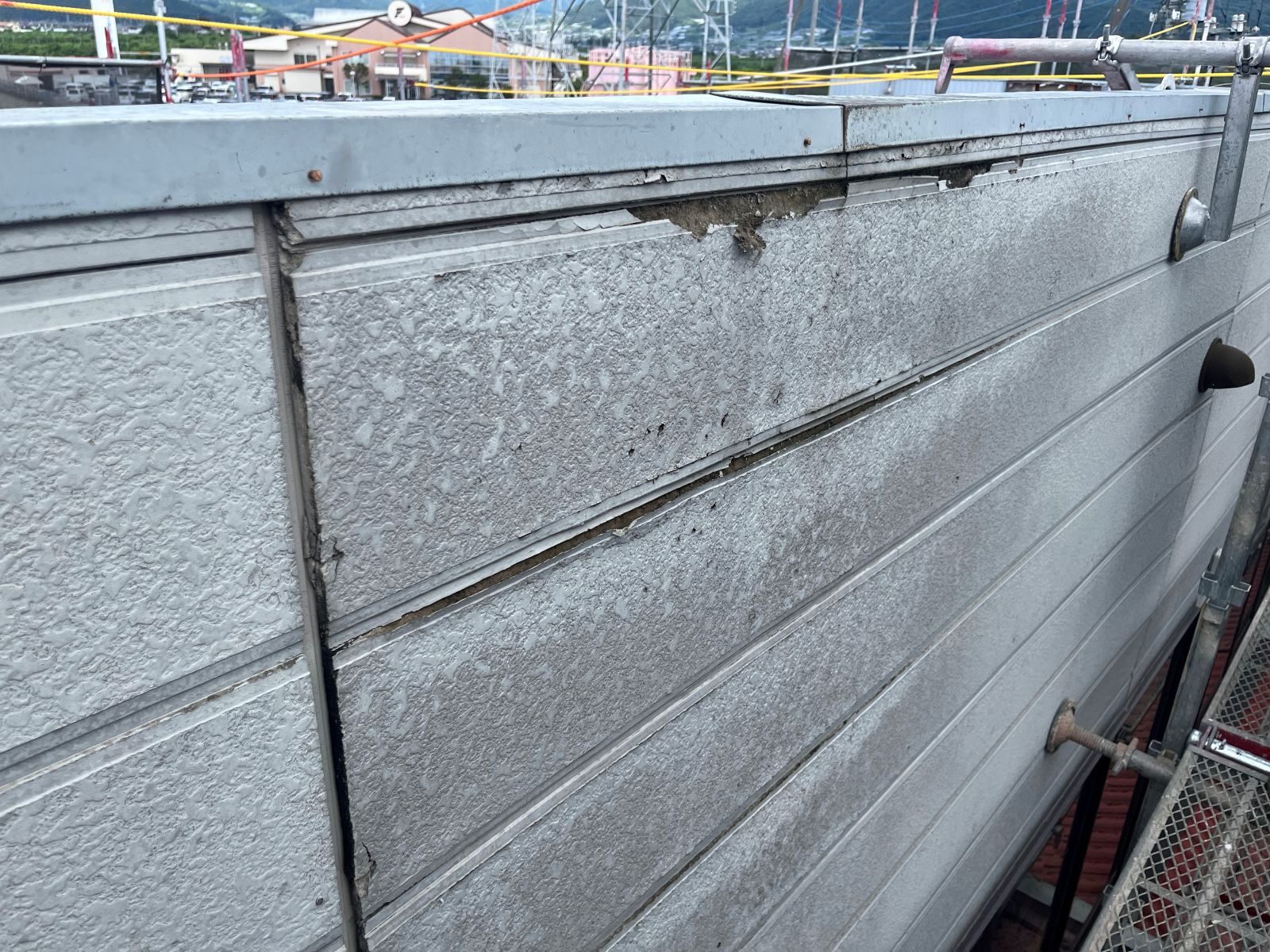 軒がなく雨風を直接受けるパラペット部分でサイディングの端部が大きく劣化している様子