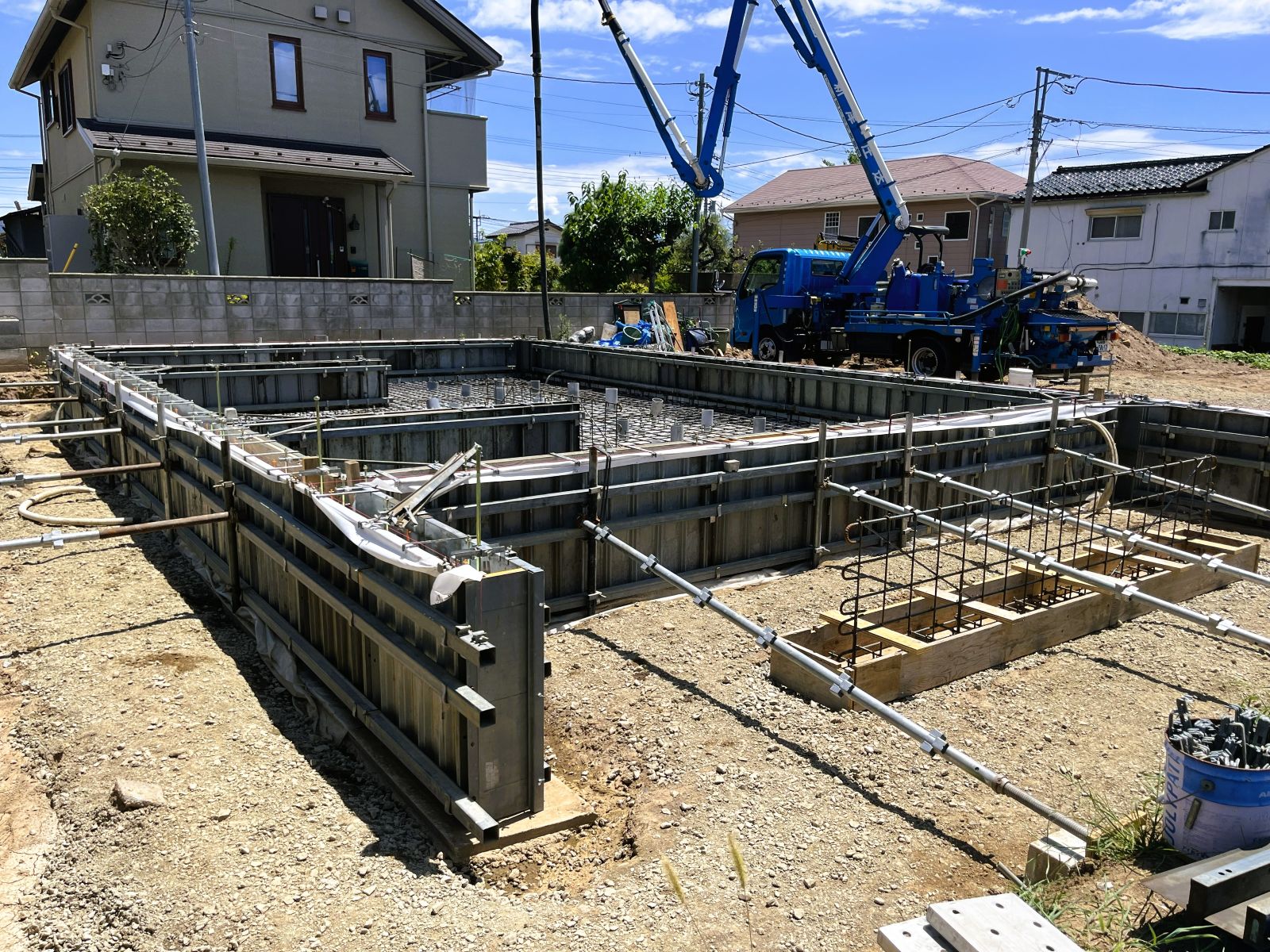 新築住宅の基礎型枠にコンクリートを打設している現場の全景