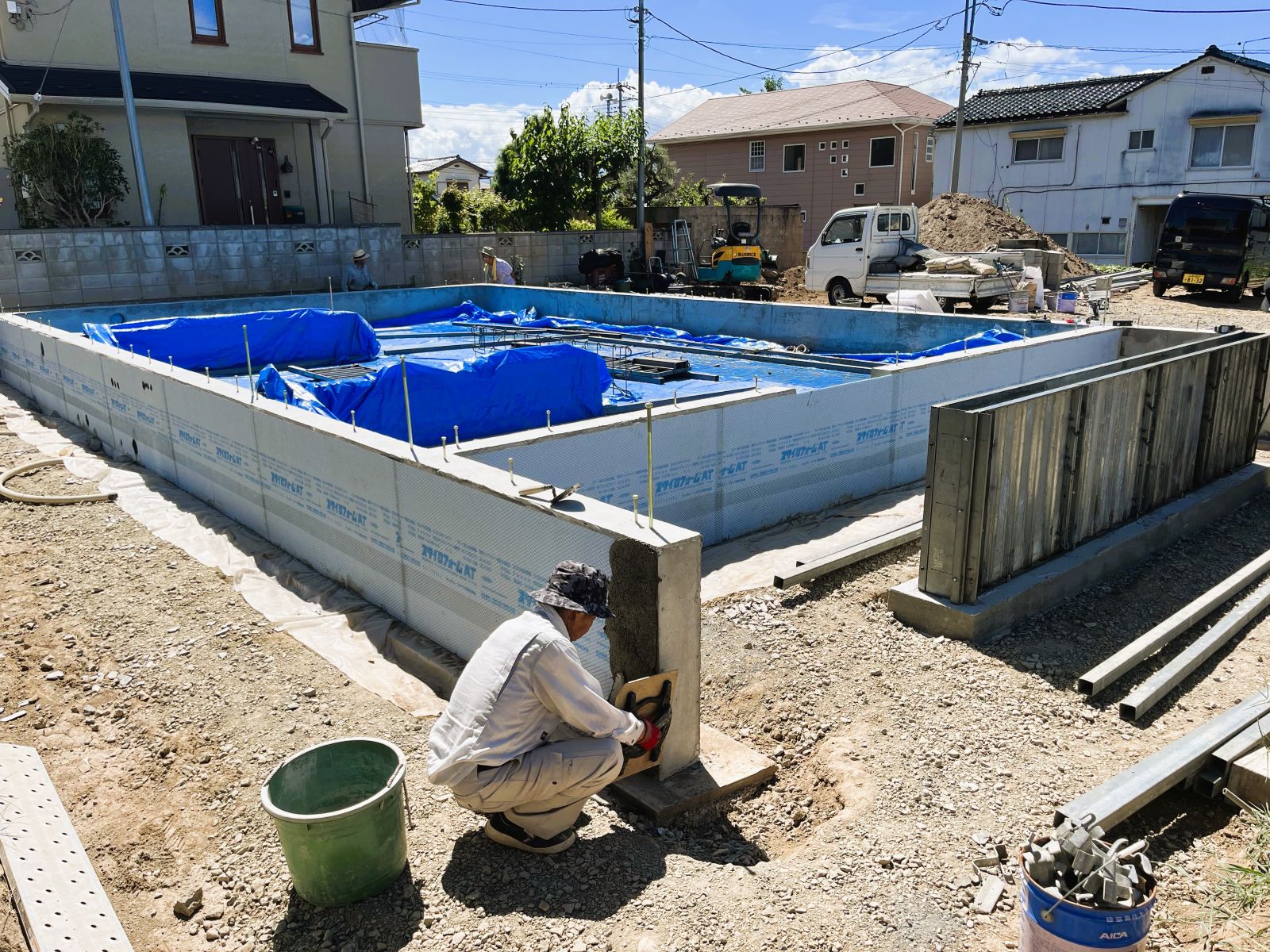 基礎の外張り断熱材の表面に保護モルタルを施工している様子