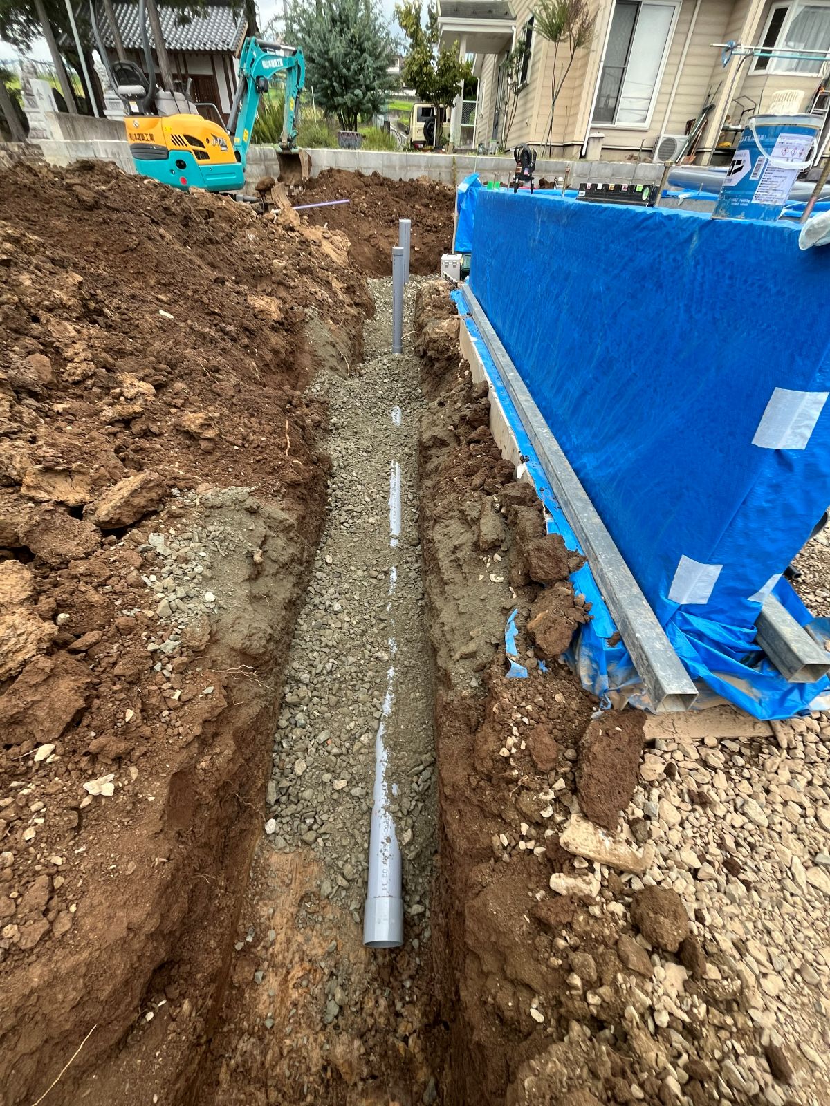 建物まわりを掘削し、雨どいや住宅設備の排水を受ける雨水配管を施工している様子