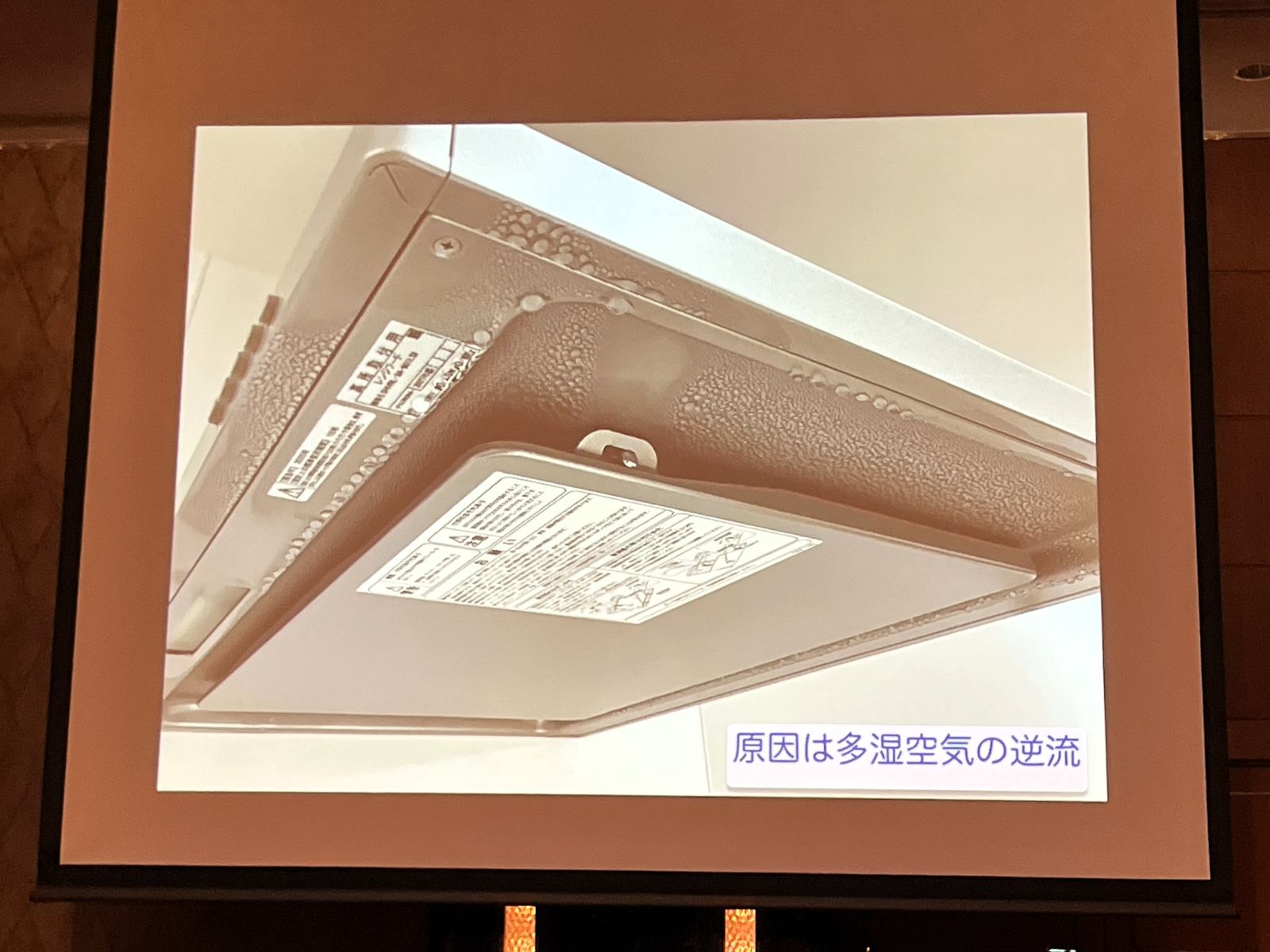 小森さんの発表でレンジフードの水滴写真と多湿空気の逆流に関する説明を示すスライド