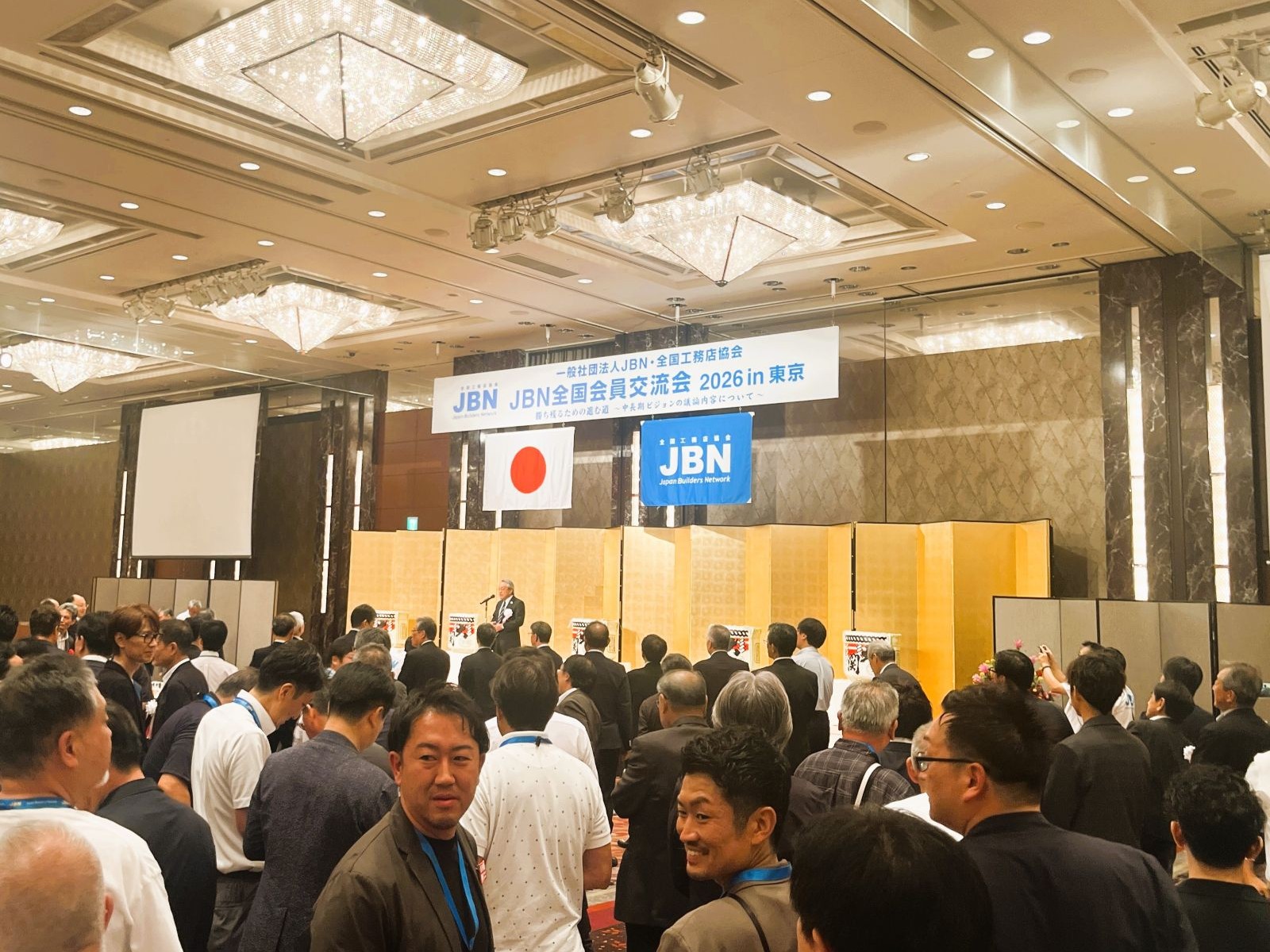 JBN全国会員交流会の懇親会で多くの参加者がテーブルを囲む会場全景